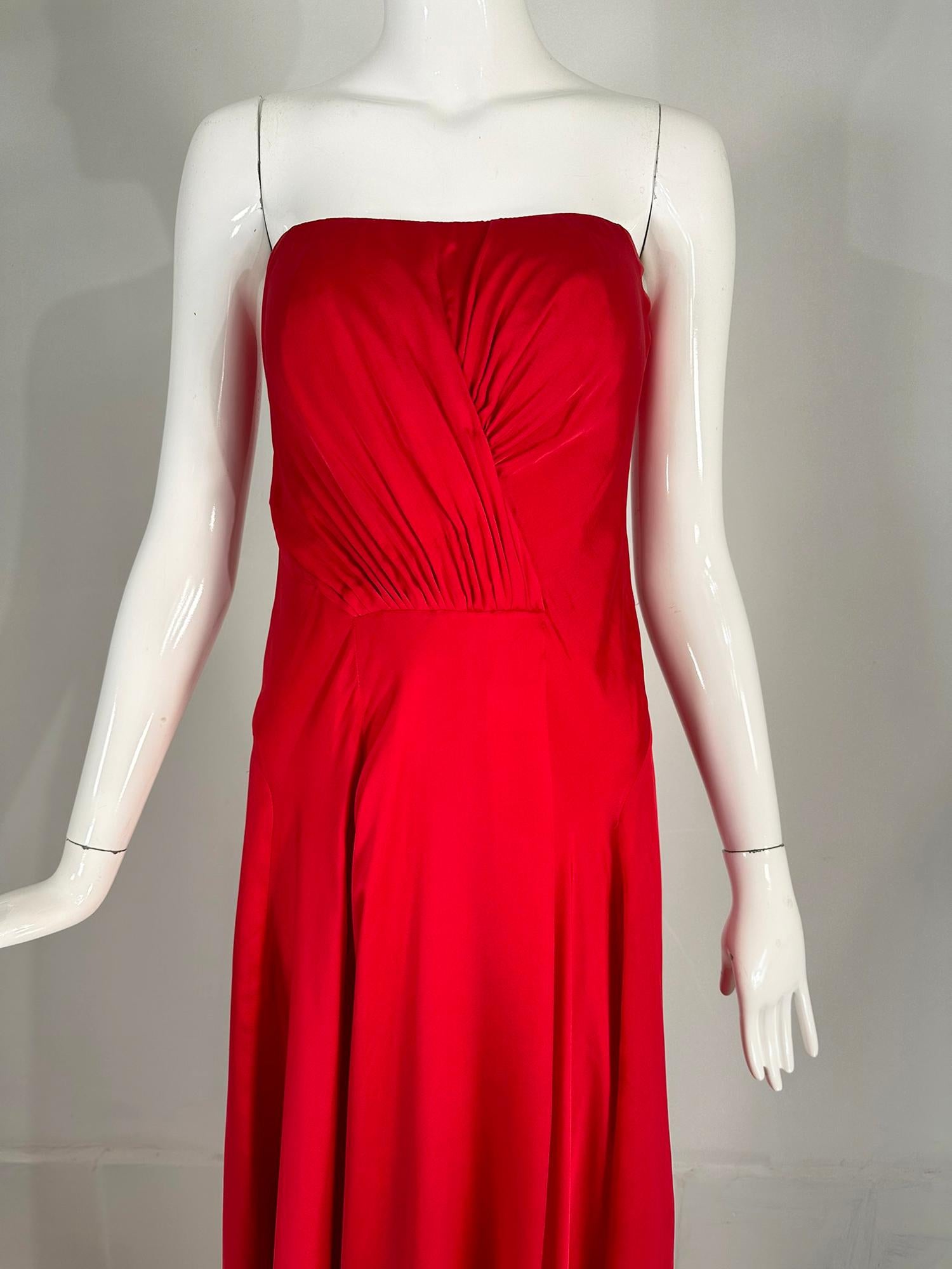 Ralph Lauren Collection draped bodice strapless evening gown with a short train. 
A beautiful fire engine red silk gown, the bodice is vertically draped to the waist, the skirt is gathered at the side waist front & falls open to the floor. The skirt