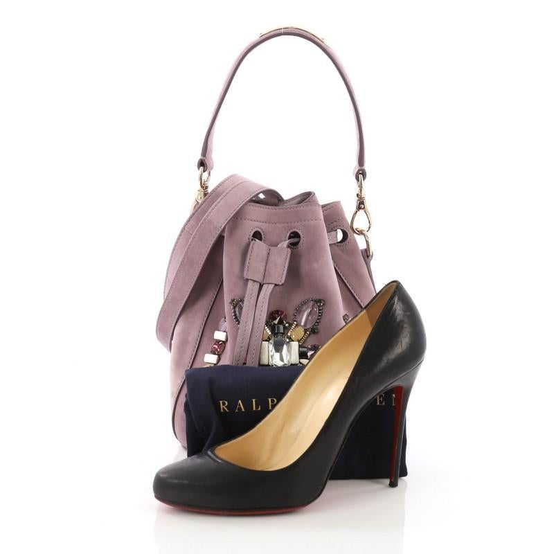 This Ralph Lauren Collection Drawstring Bucket Bag Crystal and Bead Embellished Suede Small, crafted in purple crystal and bead suede, features detachable flat top handle, long suede fringe trims sides and gold-tone hardware. Its drawstring closure