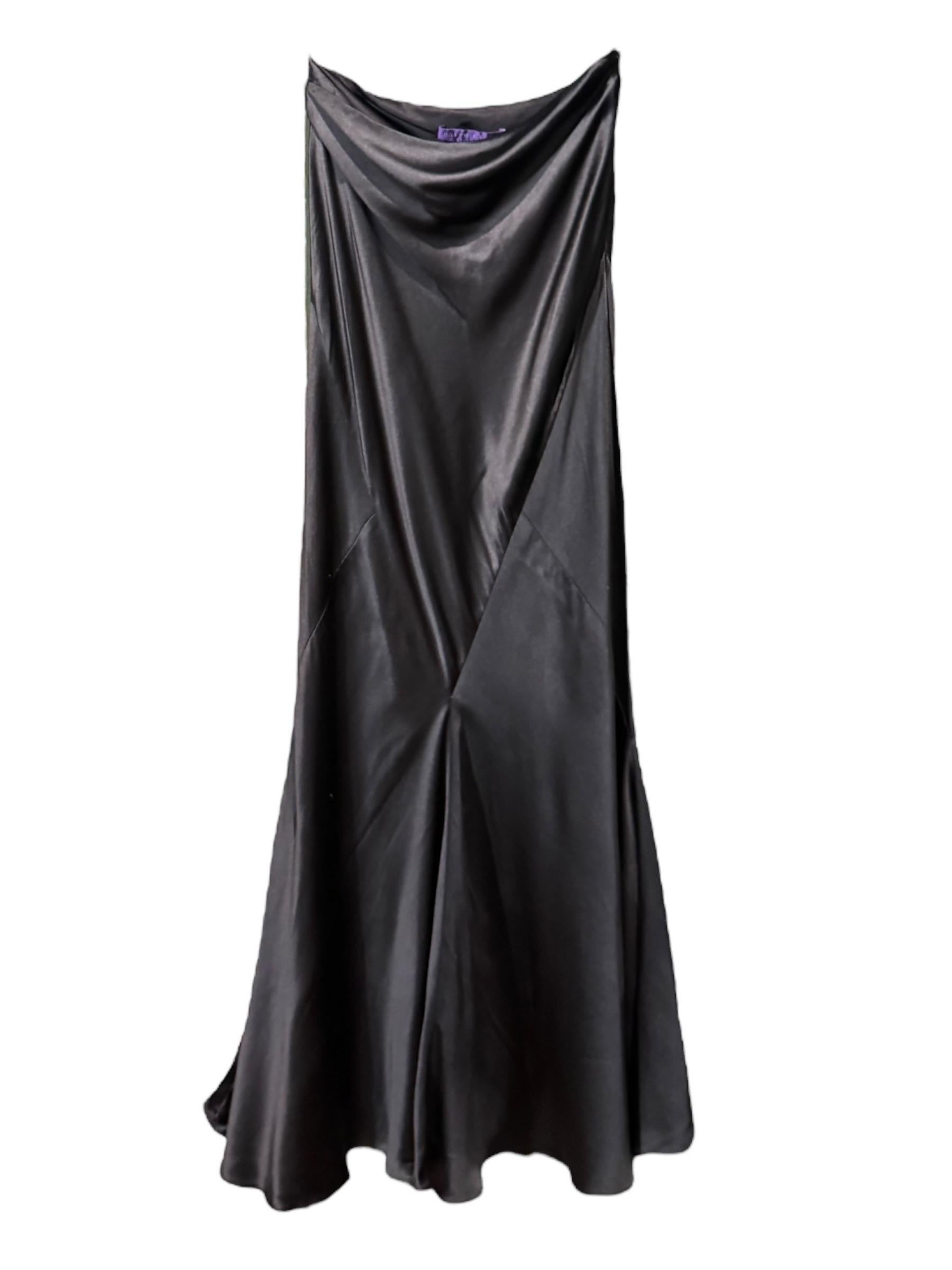 Issue de la Collectional 2005 de Ralph Lauren, cette jupe de soirée en soie noire incarne l'équilibre entre structure et fluidité propre à la maison. Coupé dans le biais avec des coutures diagonales, il se drape sans effort sur le corps et se