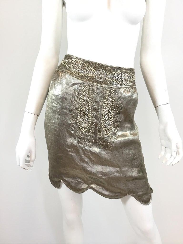 Ralph Lauren collection skirt (purple label) featured in a metallic silver lame fabric with rhinestone and beaded detailing along the front and back. Skirt has a side zipper fastening. Labeled size 10, silk and metal blend fabric, full lining. Made