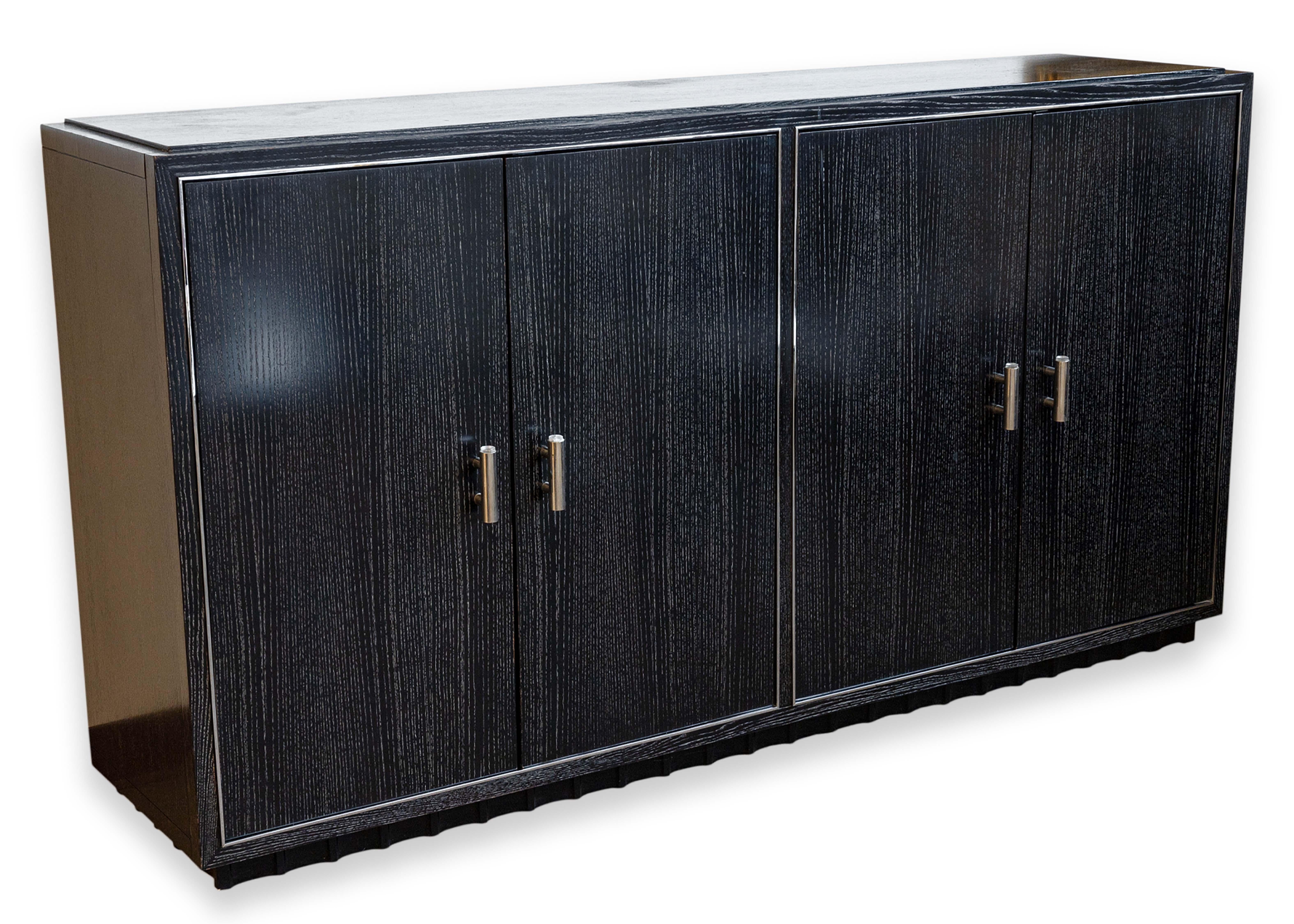A Ralph Lauren contemporary modern buffet sideboard cabinet. This gorgeous free standing cabinet features a wonderful ebonized black oak wood construction and features chrome accents all across. The chrome accenting can be seen in the trim of each