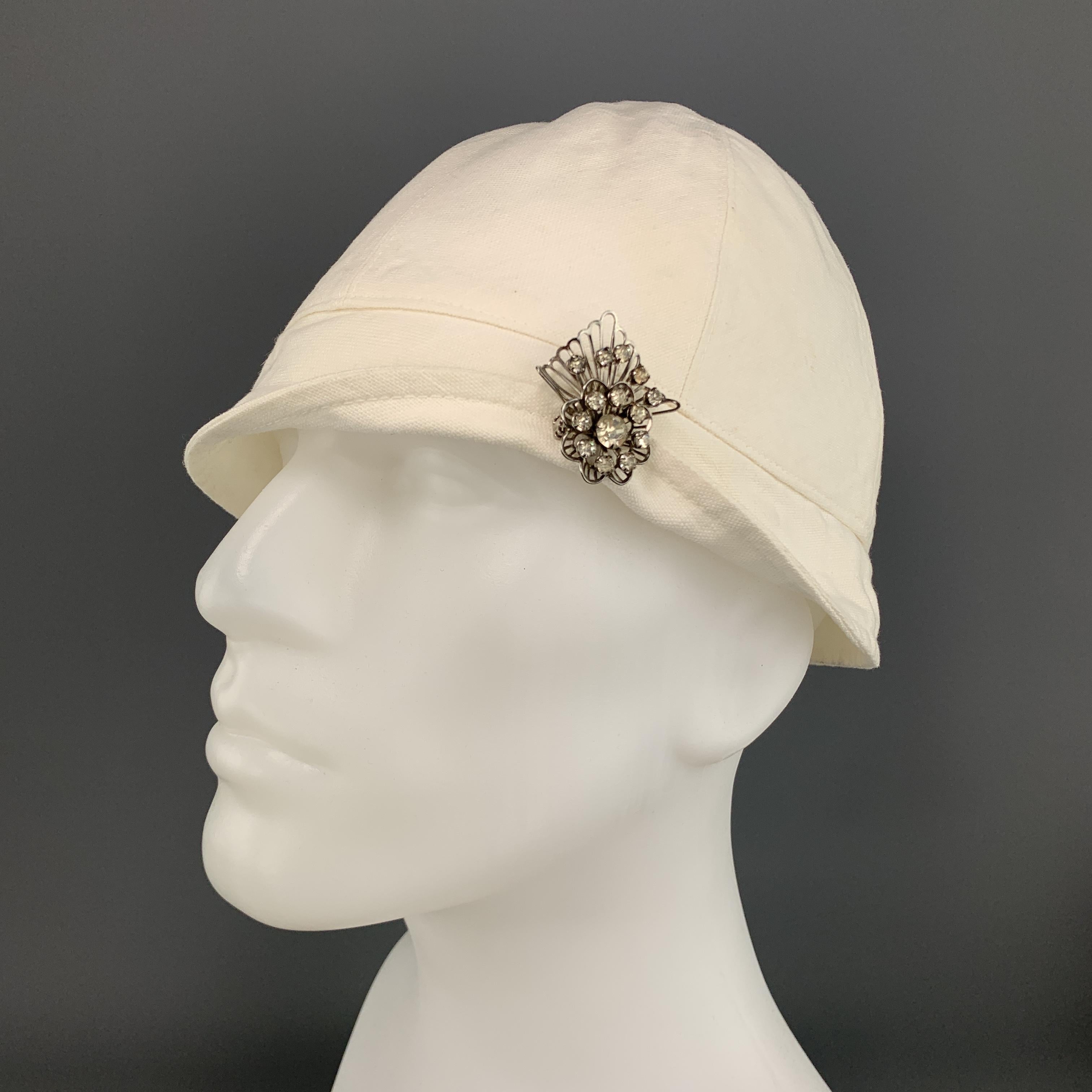 Vintage RALPH LAUREN COLLECTION PATRICIA UNDERWOOD 1920's cap comes in cream canvas with a silver tone rhinestone brooch.

Excellent Pre-Owned Condition.

Measurements:

Opening: 23 in.
Brim: 1.5 in.
Height: 6 in.