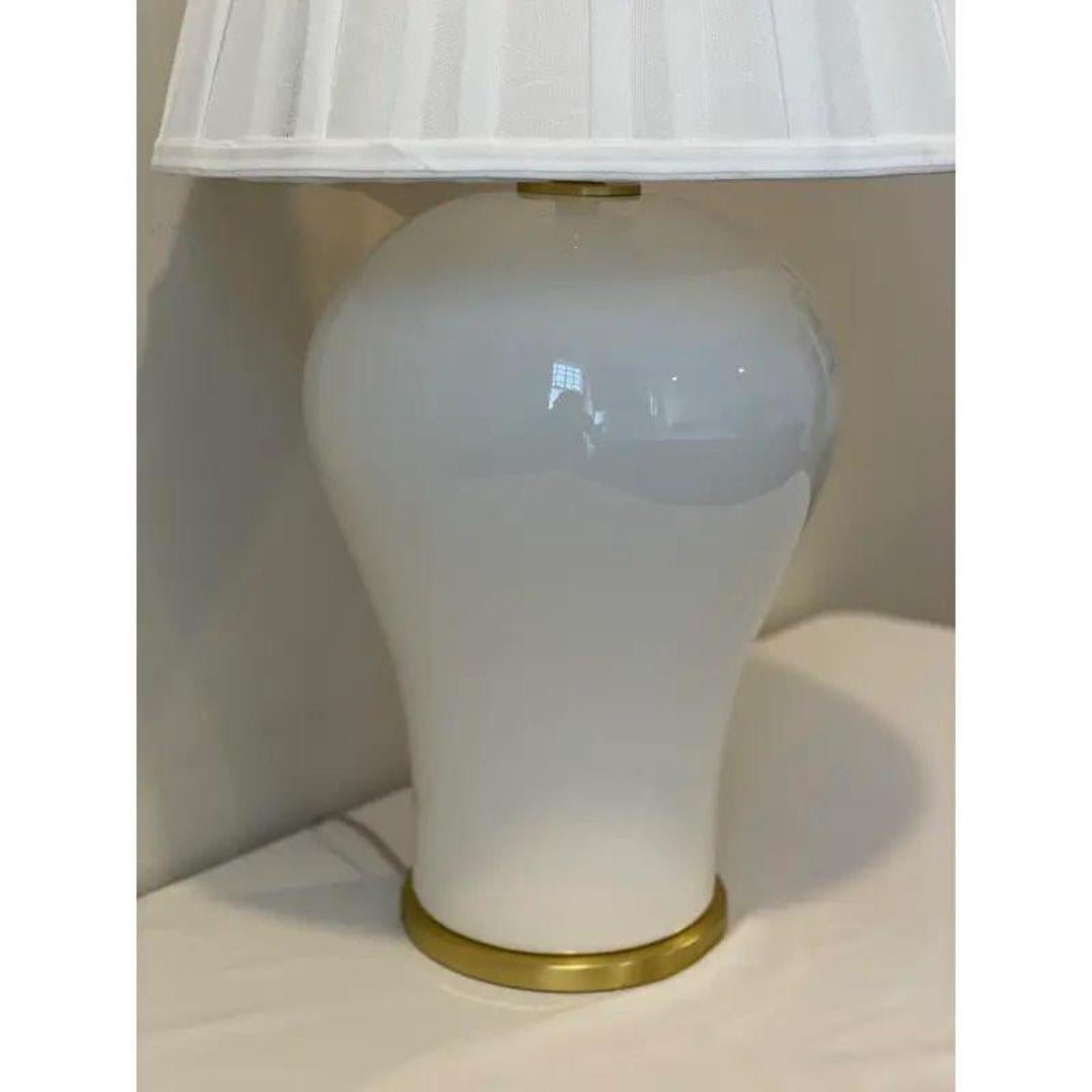 The Ralph Lauren Creamy White Crackle and Brass Ginger Jar Lamp With Pleated Shade combines classic elegance and modern sophistication. Crafted with precision, its crackle ceramic base in creamy white is complemented by a sleek brass neck and