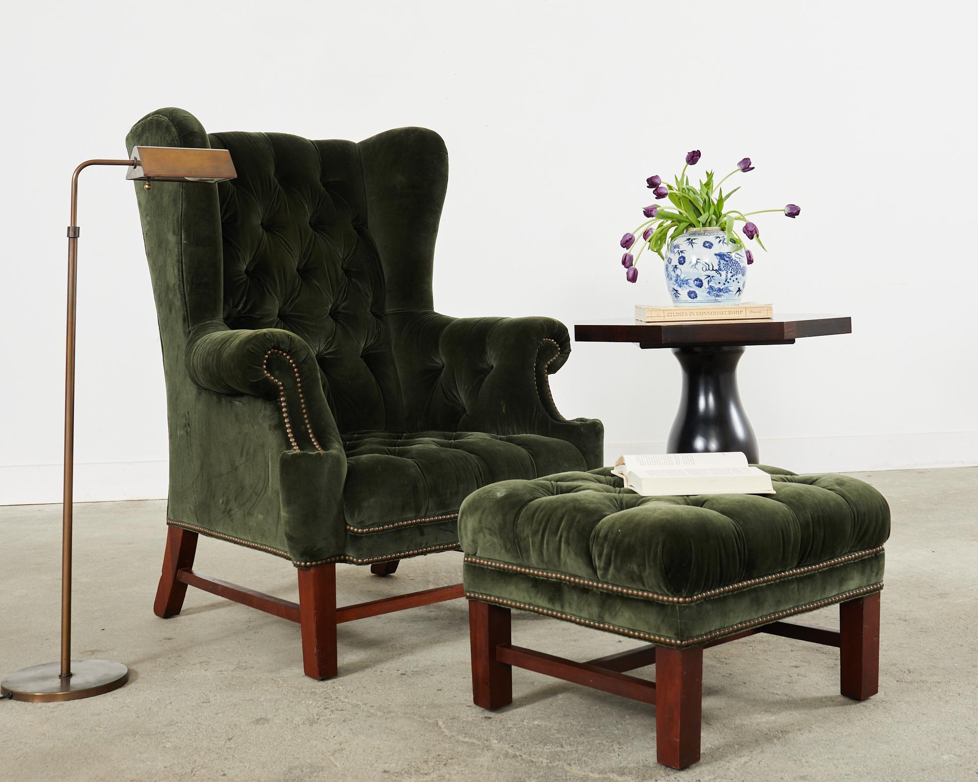 Stately English Georgian style Devonshire wingback armchair designed by Ralph Lauren for Henredon. The grand chair features a large beechwood frame with fully developed wings and a matching ottoman. The frame is upholstered with an Italian velvet