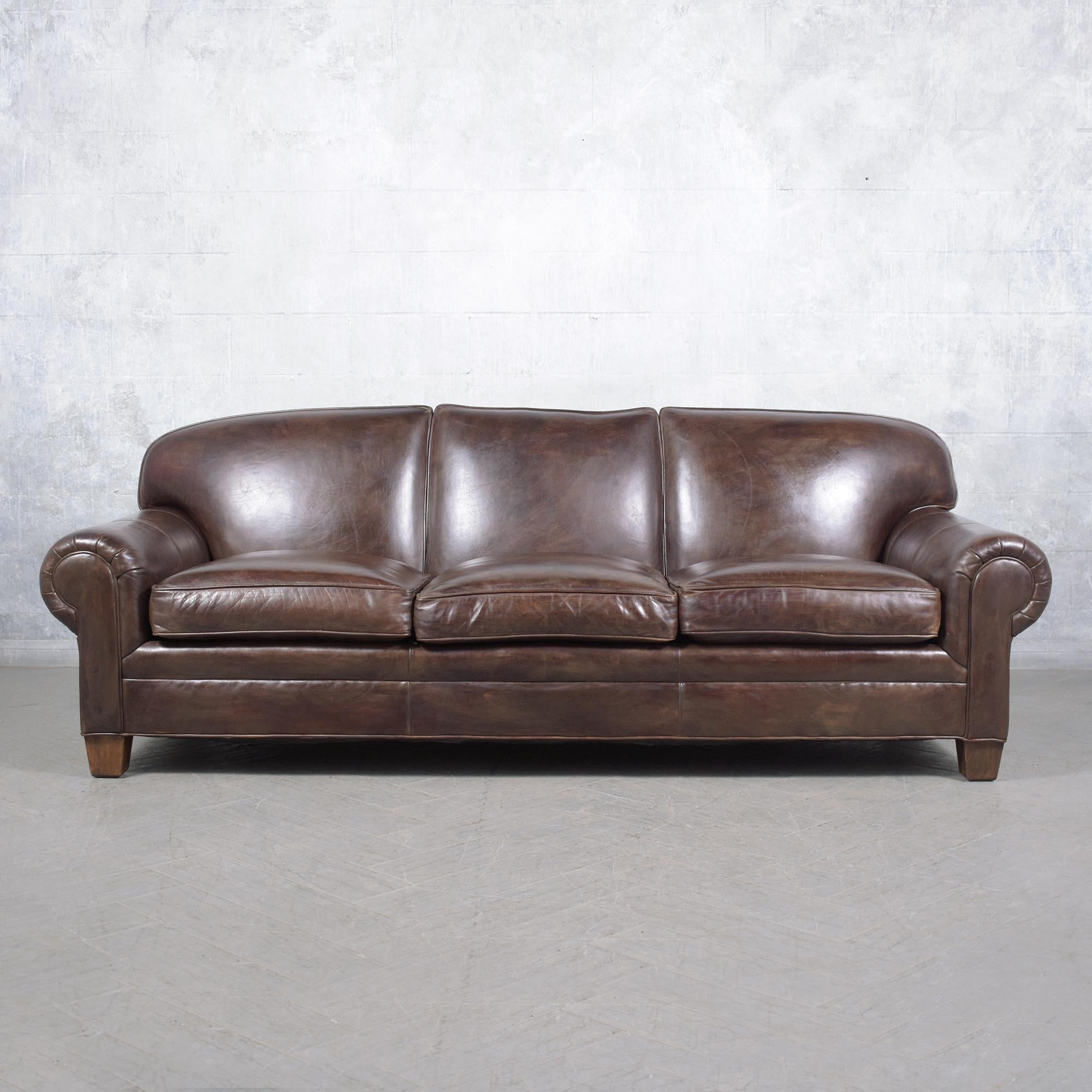 Experience the classic allure of our Ralph Lauren three-seat sofa, recently restored to showcase its luxurious dark chocolate brown leather upholstery. This sofa, featuring a traditional English roll-arm style, blends timeless elegance with superior