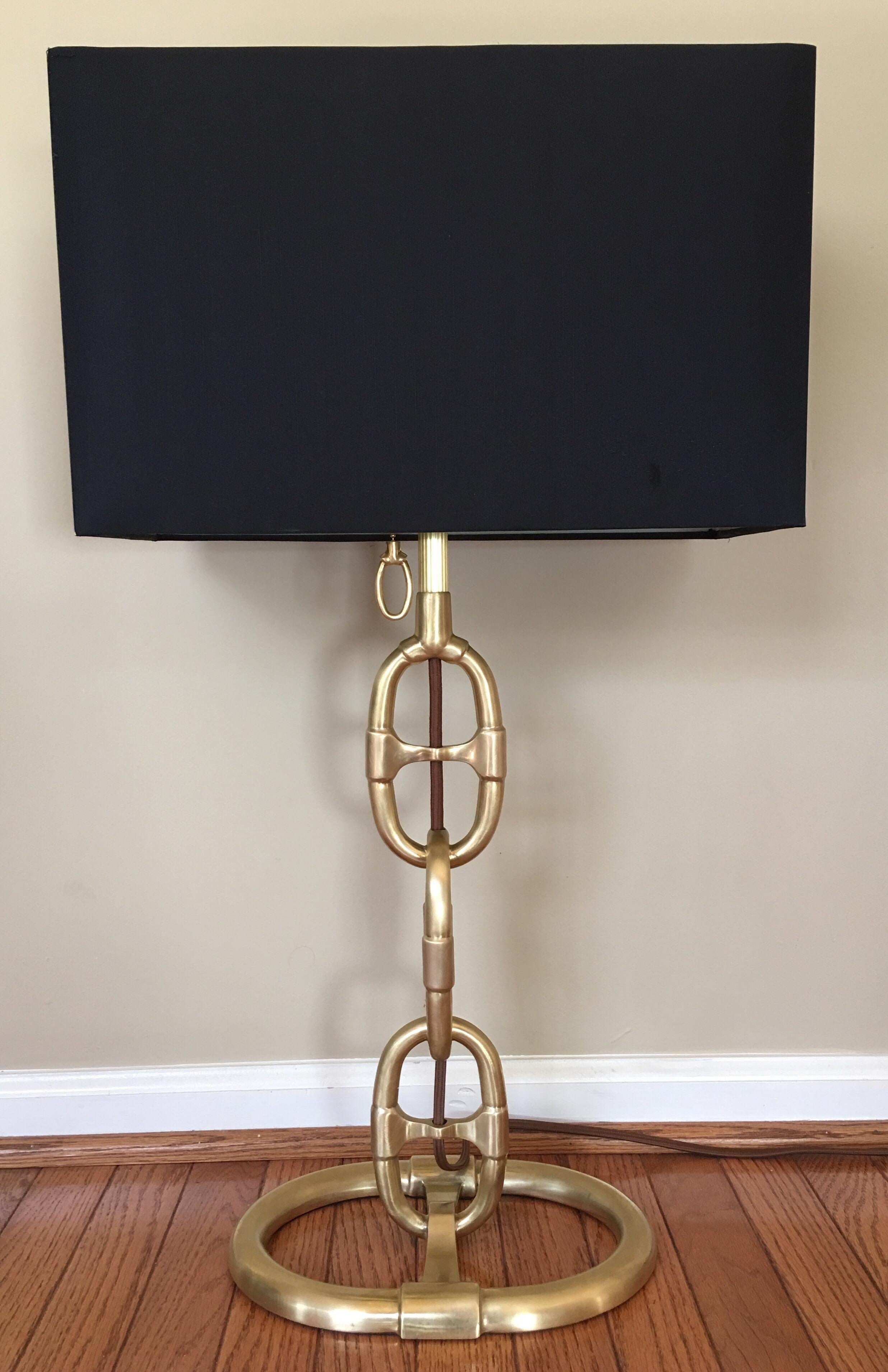 Ralph Lauren Jasper table lamp in aged brass finish. Blending modern and industrial design influences, this table lamp features a chain-link or horse bit style body. Lamp shade not included. 

29½