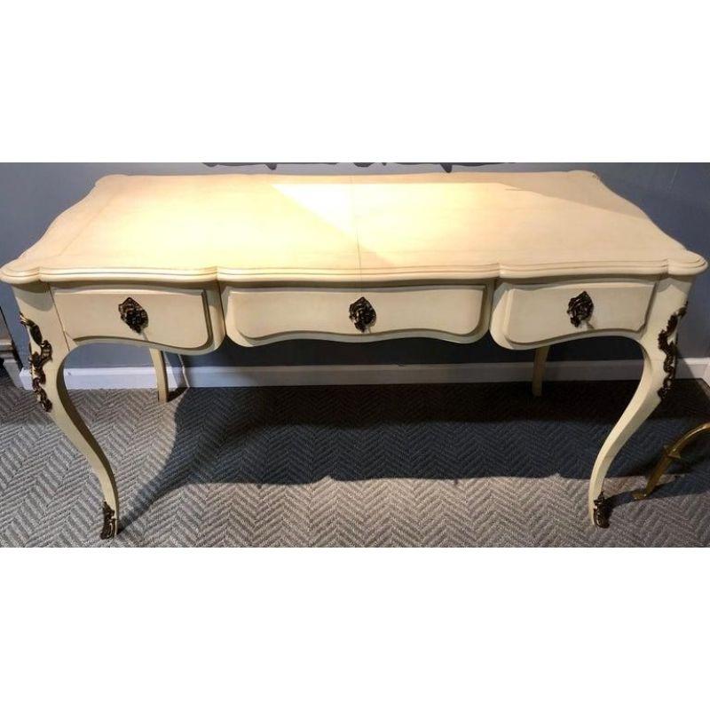 Designed by Ralph Lauren, this beautiful Louis XV desk will carry grace and traditional style into your home. With elegant curves throughout, the desk features a scalloped top, saber legs decorated with brass corner and feet mounts, decorative