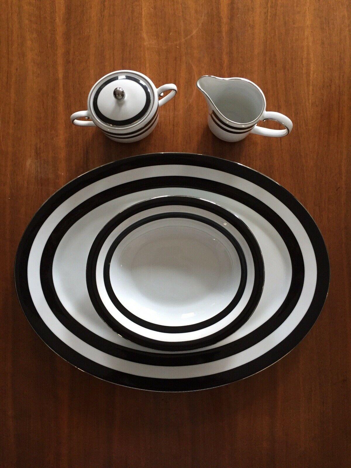 A four-piece porcelain serving platter in the spectator black pattern by Ralph Lauren Home Collection. Signed. Portugal, circa 1995-1996.

Includes oval serving platter, vegetable serving bowl, creamer and lidded sugar bowl.

Features a black