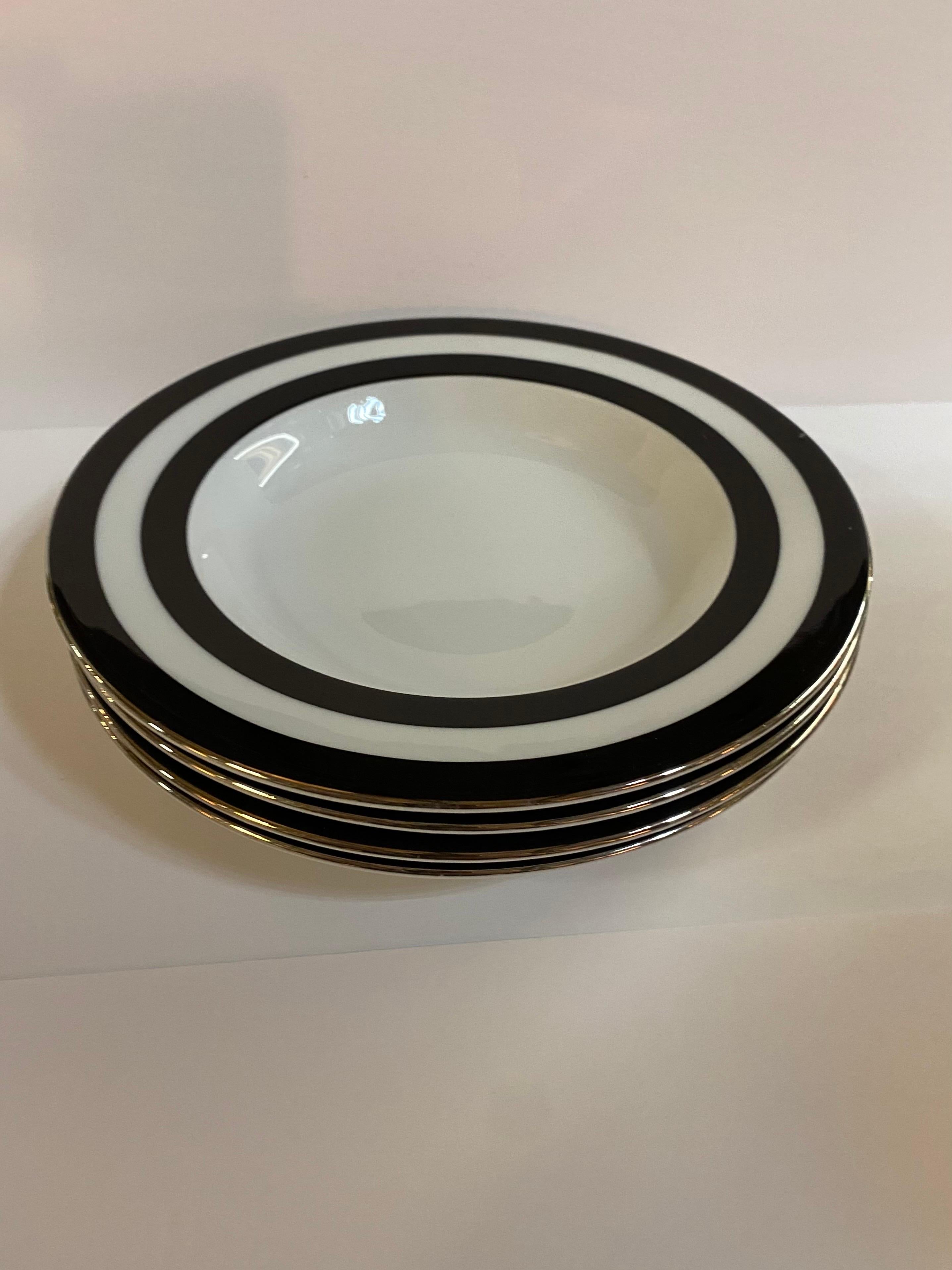 A set of 4 (four) rim soup / pasta bowls in the Spectator black pattern by Ralph Lauren Home. Porcelain. 

Signed. Made in Portugal, circa 1995-1996.

White with black wide stripe border and silver trim.

Includes 4 (four)