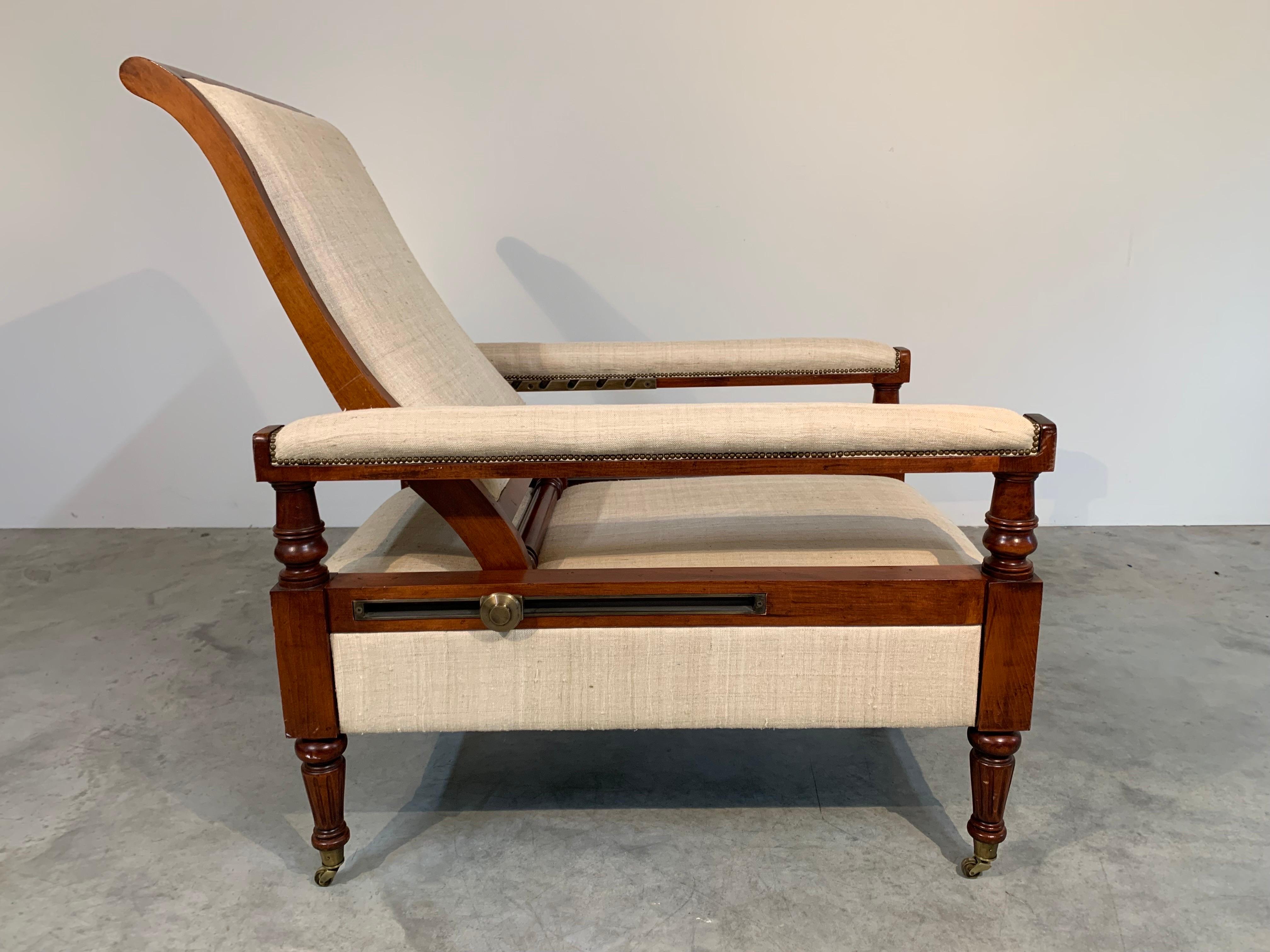 A rare and beautifully designed lounge chair by Ralph Lauren Home having mahogany frame with cotton linen upholstery and brass hardware over brass casters.
Manufactured by Henredon. 
 The backrest is seat depth and tilt adjustable. The seat depth