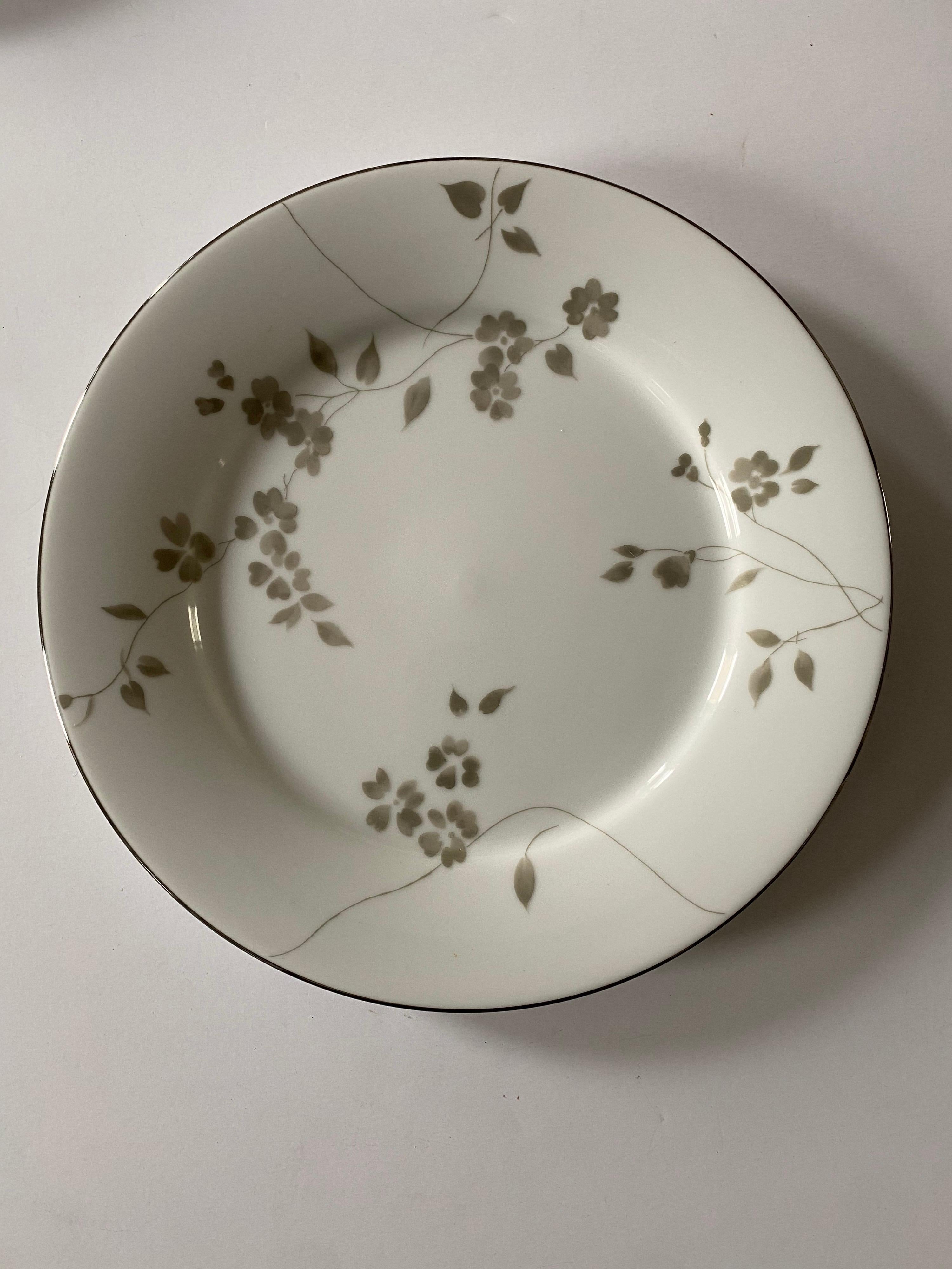 A 12 piece set of dinnerware by Ralph Lauren Home in the Sophia floral pattern, a Romantic pattern of gray/pale green scattered flowers on white, complemented by platinum trim. 

Includes the following 12 (twelve) pieces:
4 Dinner plates, 10-3/4