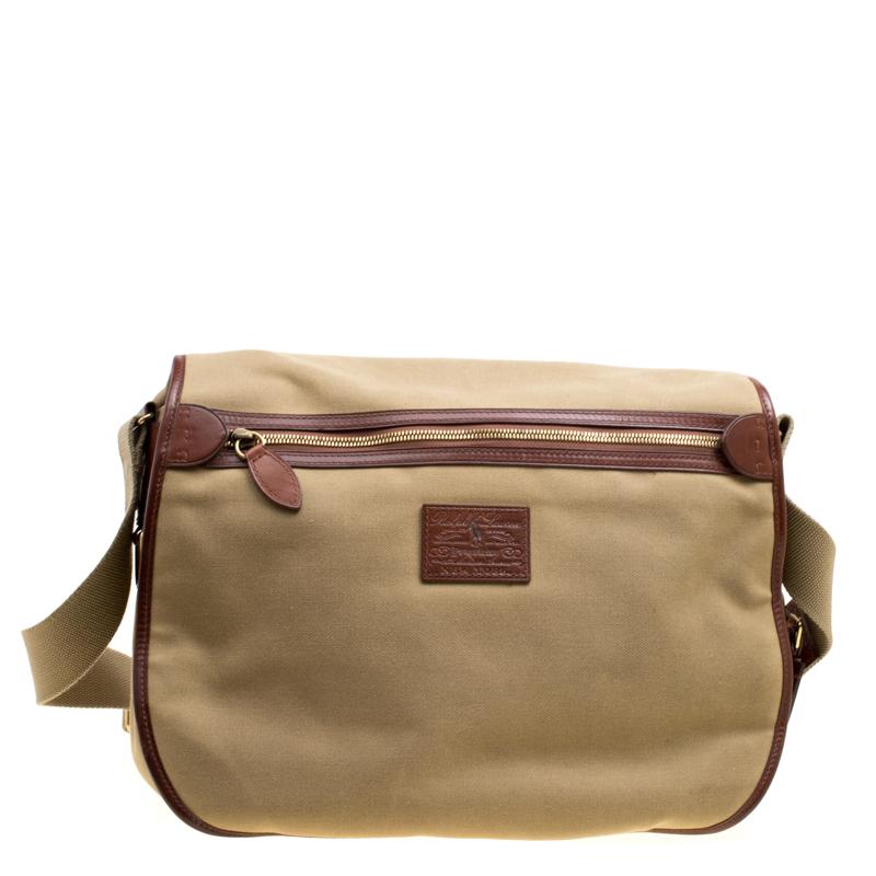 This messenger bag from Ralph Lauren will give an opportunity for your peers to relish in your personal style. It is made of khaki fabric with brown leather trims and gold-tone hardware accents. It features a front flap secured by buckle fastenings.