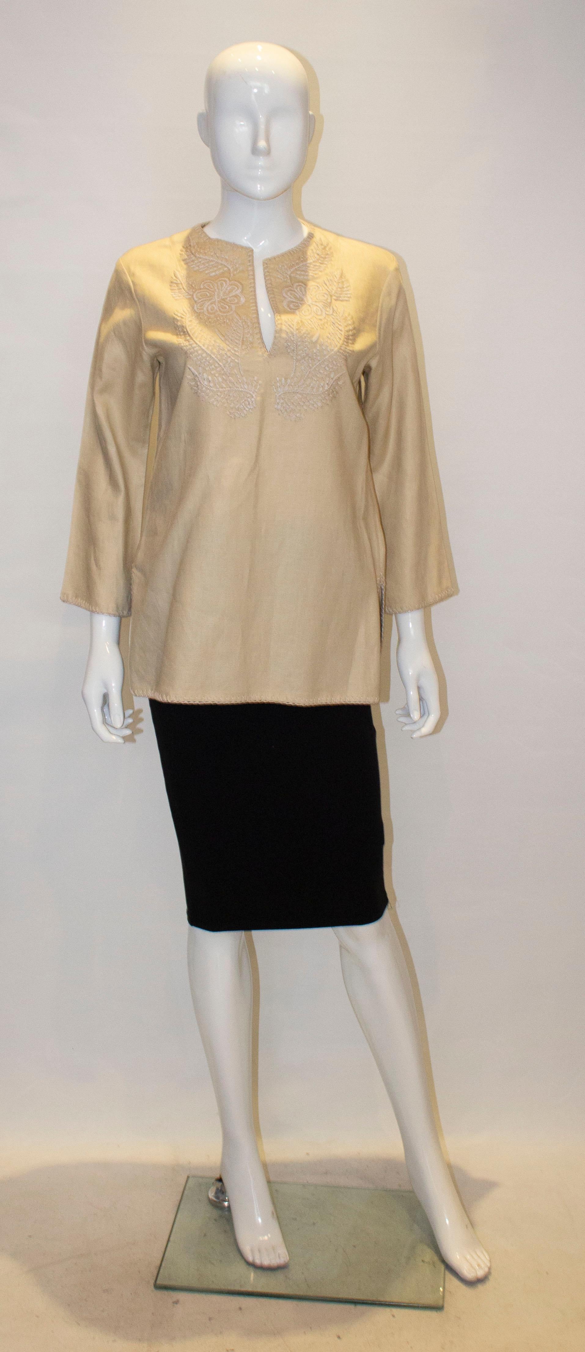 A chic top for Spring /Summer by Lauren for Ralph Lauren.The top is a biscuit colour linen with elbow length sleaves and deocration around the neckline  and hem. There is a 7 ''  slit on either side. 