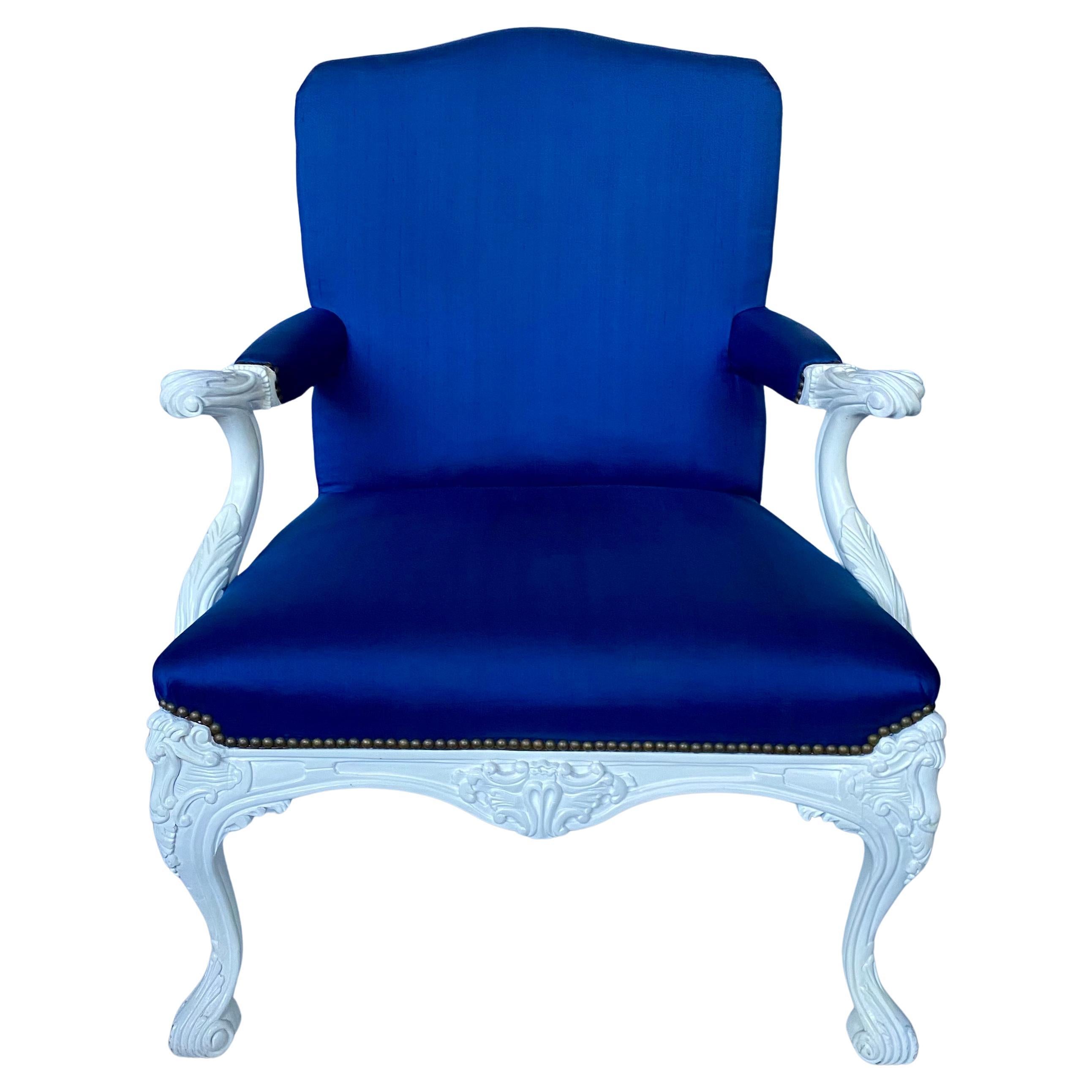 Beautiful English Georgian style ornately carved armchair by Ralph Lauren for Henredon Furniture.  This French inspired generously scaled bergère chair features original RL white gloss painted finish with aged brass nail heads and blue silk