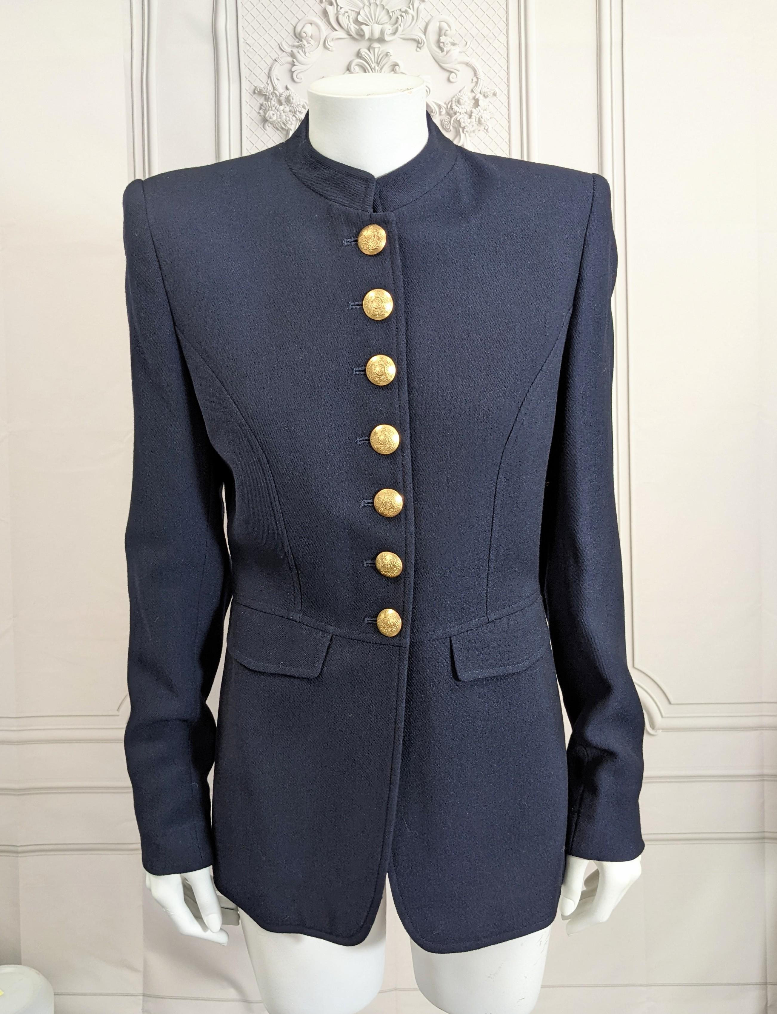 Ralph Lauren Military Style Jacket in navy wool twill with band collar and gilt buttons. Elongated slim cut with princess seaming, functioning pockets at waist level. Bold shoulders with button decorated pleats and flap on back. Beautifully tailored
