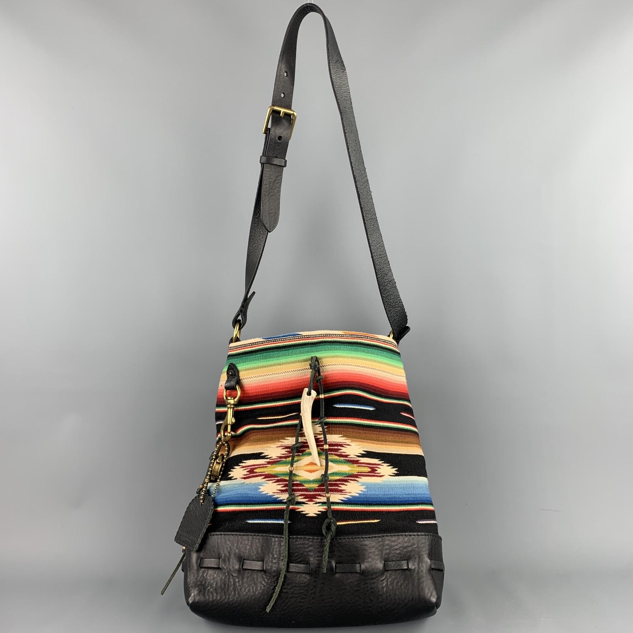 RALPH LAUREN shoulder bag comes in a multi-color navajo print fabric with a leather trim featuring hanging leather tassel details, tusk charm, signature lock & key, open top, inner pockets, and a adjustable shoulder strap.

Very Good Pre-Owned