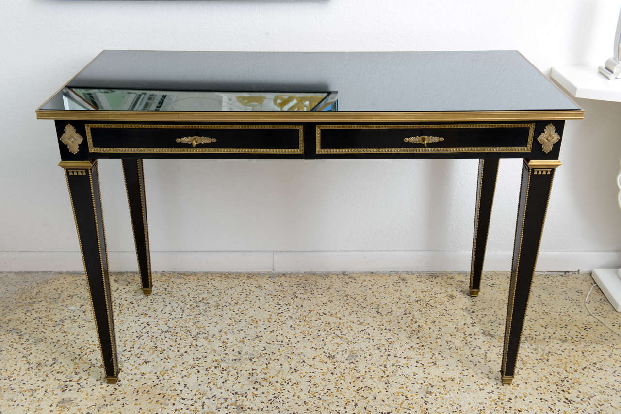 This stylish and chic Louis XVI style console table was acquired from a Palm Beach estate and dates to the 1980s and was created by Ralph Lauren Home collection. The piece has a smoked glass top to keep the surface protected from daily use.