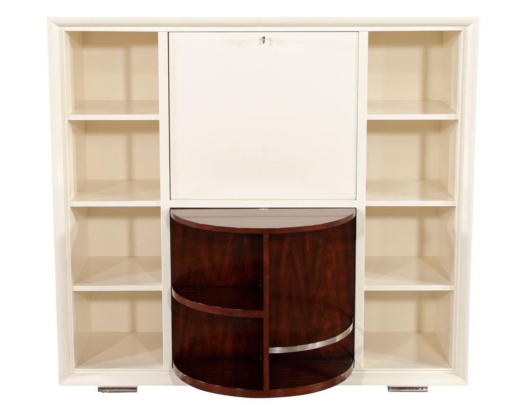 Ralph Lauren one fifth bar cabinet. This transitional style bar cabinet is retro and utilitarian. It has a tripartite bar, display cabinet and central drop leaf mixing surface with a faux shagreen front. It is finished in a lovely parchment