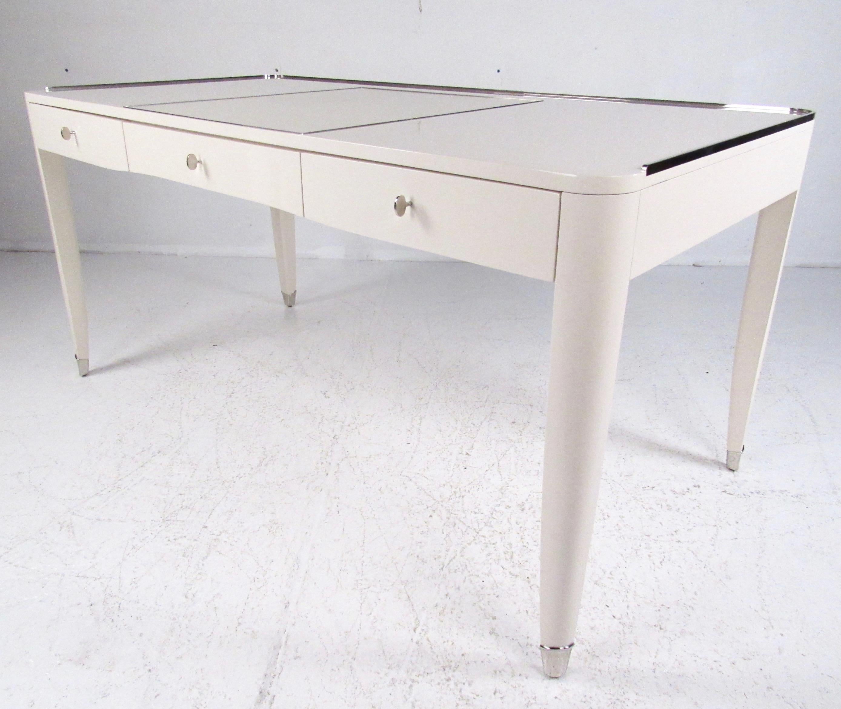 The Ralph Lauren One Fifths Paris desk offers spacious writing surface and three drawers for office storage. This beautiful modern desk features parchment coloring, polished nickel trim, and elegant 1920s style French design. Please confirm item