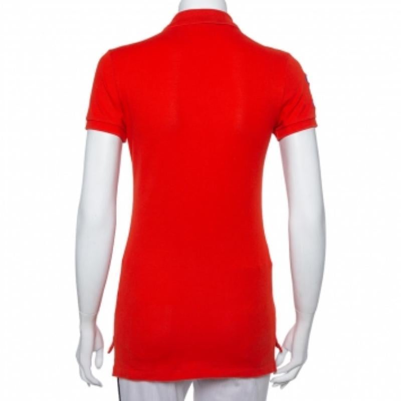 This stylish polo t-shirt comes from the house of Ralph Lauren. Crafted from cotton, it comes in a lovely shade of orange. It is styled with logo embroidery on the front and one sleeve. It comes with a simple collar, button front, and short sleeves.