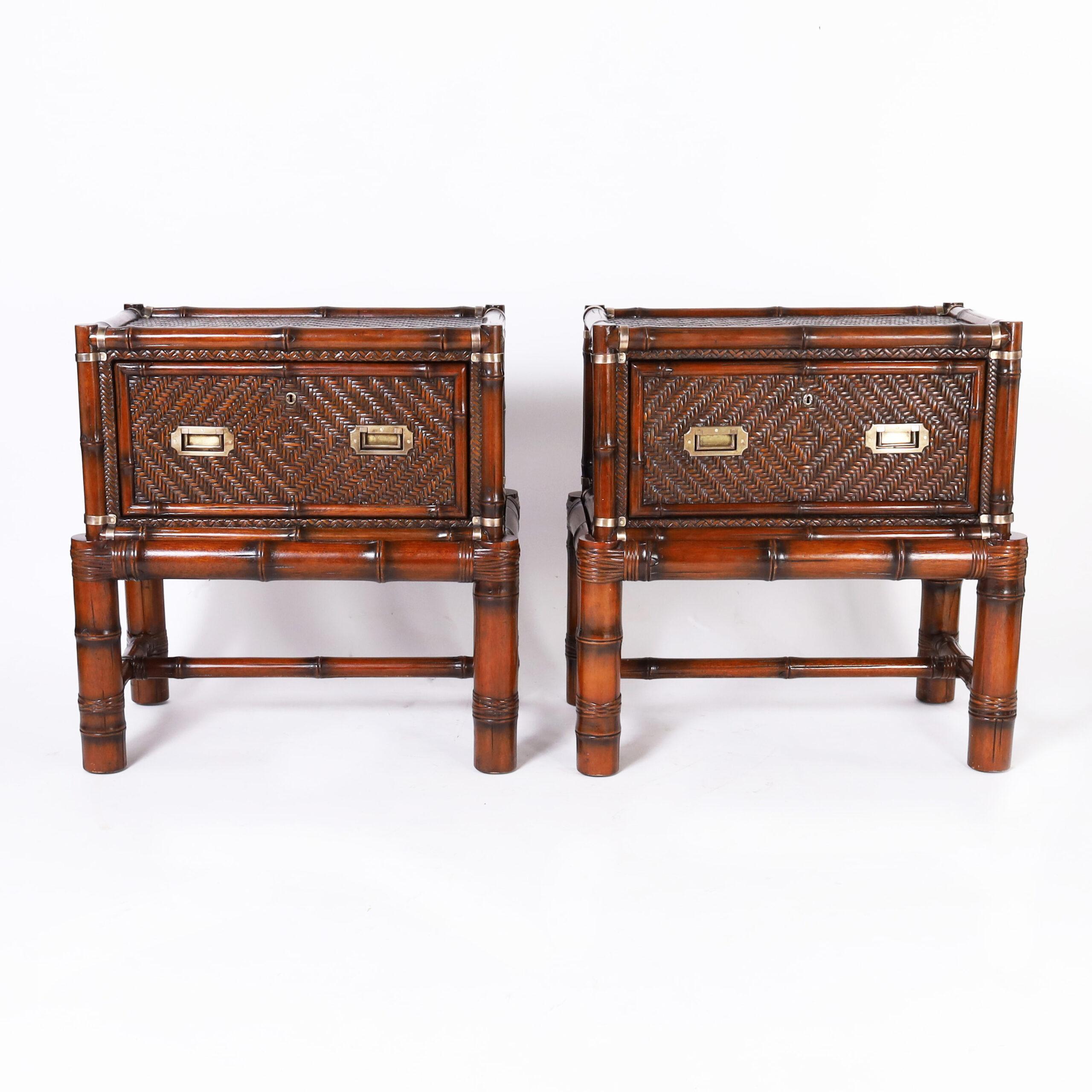 Standout pair of vintage British colonial style one drawer stands crafted in a two piece construction, having a case with a bamboo frame, herringbone woven rattan panels, and campaign style brass hardware on a bamboo base with reed wrapped joints.