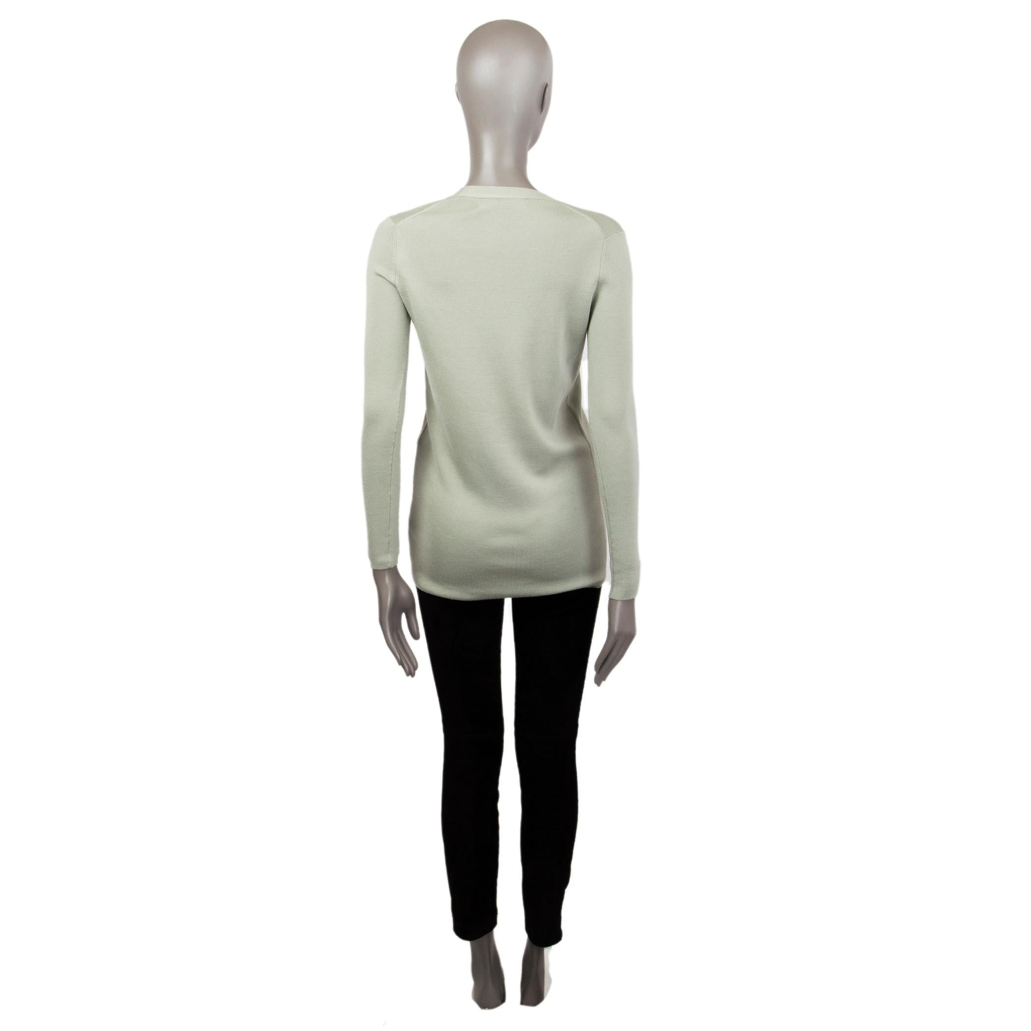 Cardigan mi-long 100% authentique Ralph Lauren en laine (70%) et soie (30%) vert pastel avec encolure en V, manches longues, deux poches plaquées sur le devant, coupe près du corps. Se ferme par des boutons à effet perlé sur le devant. A été porté