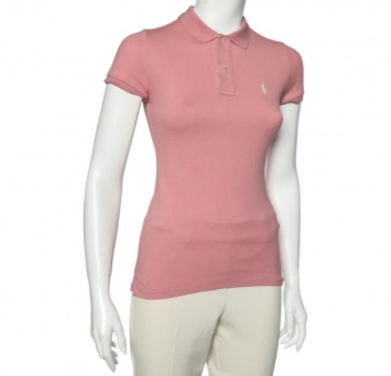 Le polo Ralph Lauren sono sempre state un classico per le donne. Questa versione è realizzata in cotone-piqué di colore rosa e rifinita con l'iconico logo e l'abbottonatura. Completa il tuo look casual con un paio di pantaloncini e scarpe da