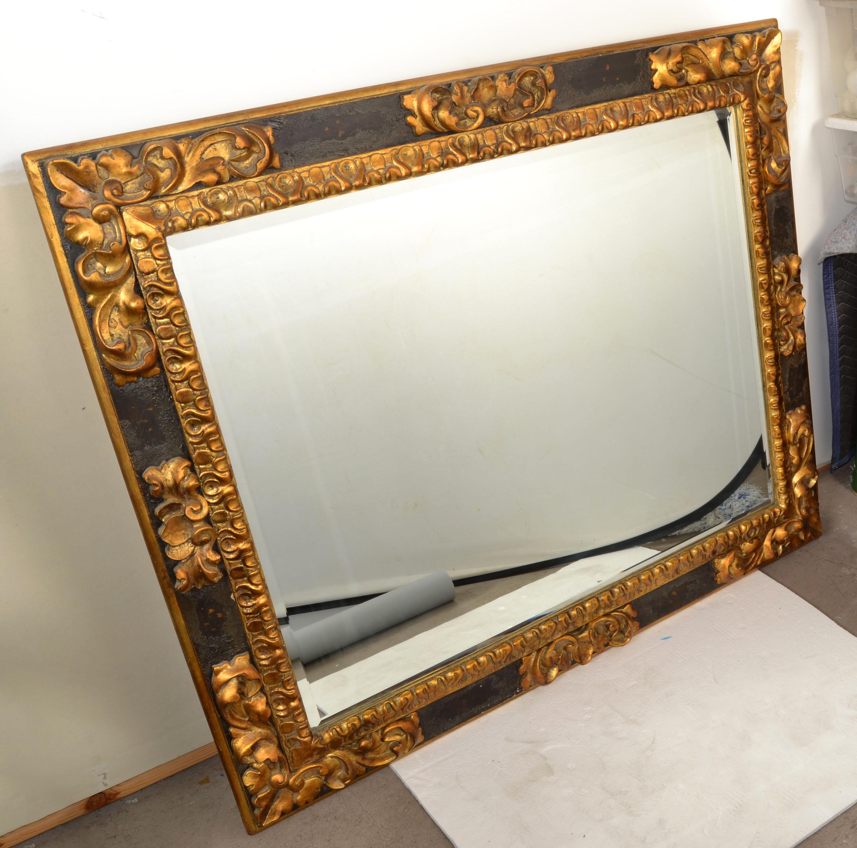 American Neoclassical large rectangle Wall Mirror in Black Finish framed with hand carved Acanthus Scroll Design in Giltwood.
The Mirror Glass has a beveled edge and sits tight in the decorative giltwood inner border.
The heavy Mirror is supported