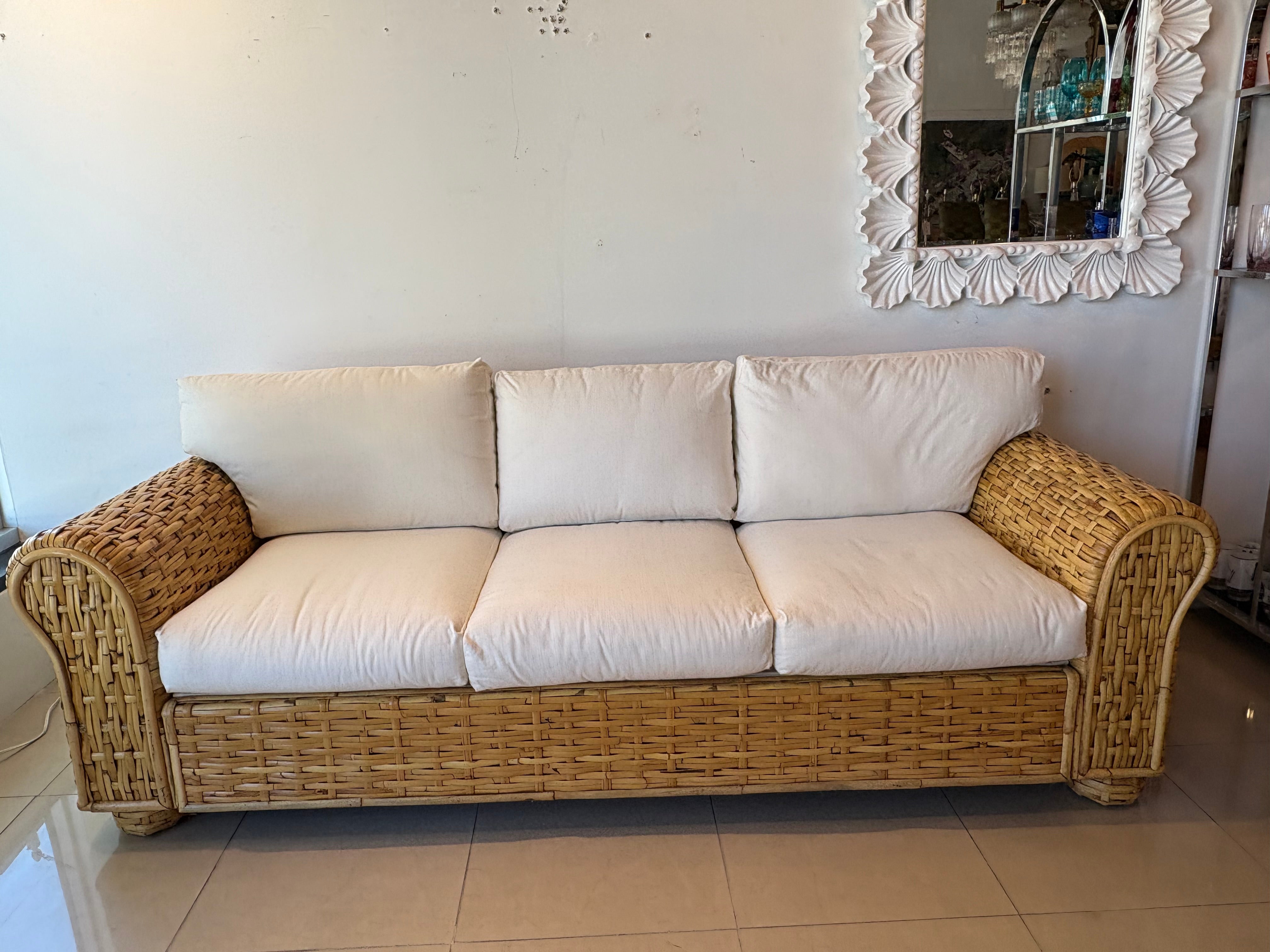 Late 20th Century Ralph Lauren Polo Home Collection woven rattan, wicker sofa. No damage to the woven rattan. The recently upholstered white cushions are in good condition. The only stain I was able to see is on the side of the cushion that is on