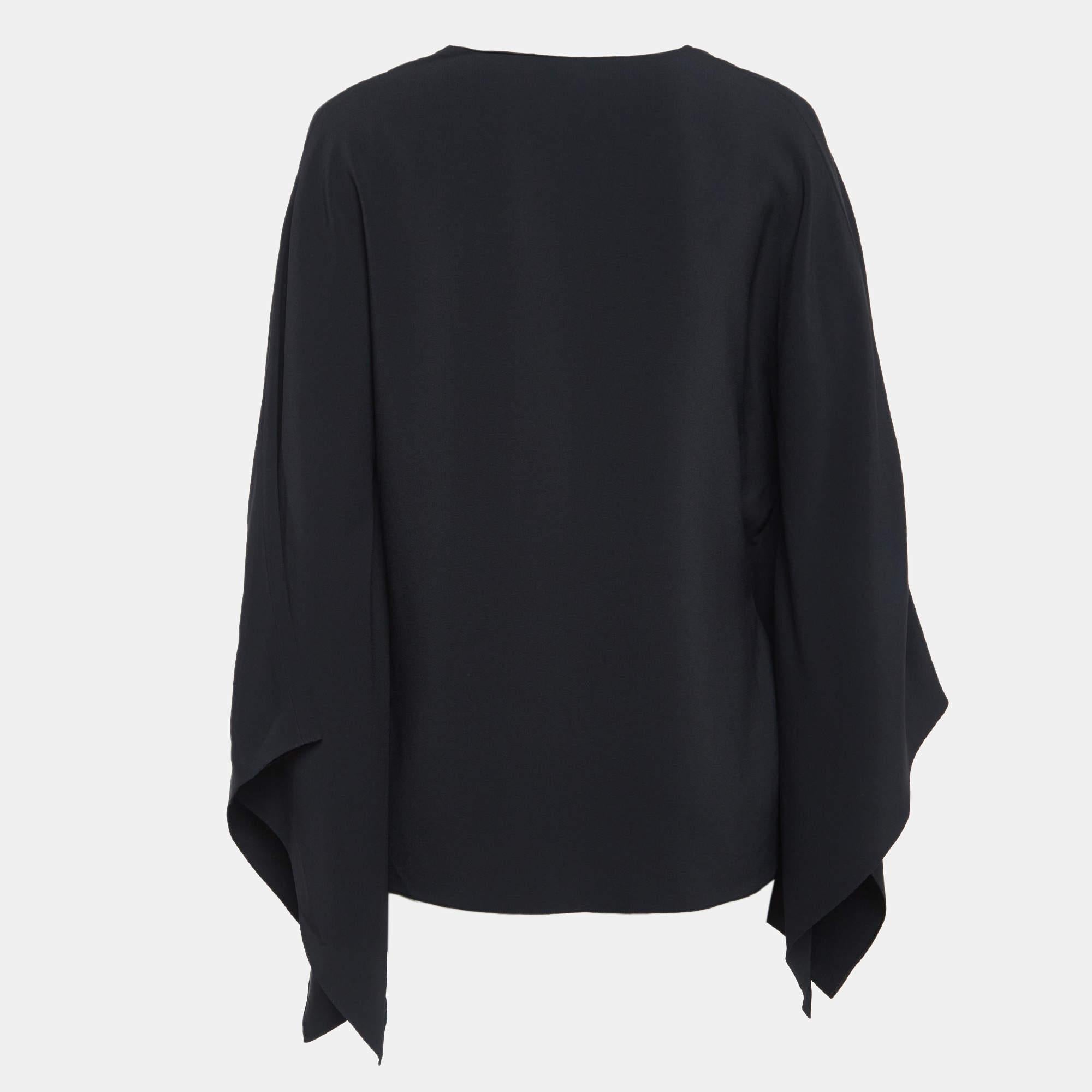 The Ralph Lauren Purple Label cape blouse offers sophisticated allure with its sleek crepe fabric and intricate embroidery. This blouse features a cape design that drapes gracefully blending modern elegance with classic craftsmanship. Perfect for