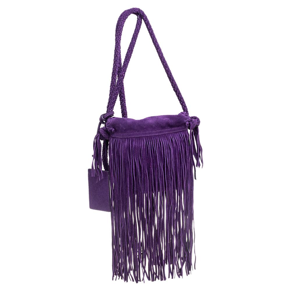 This stunning bag by Ralph Lauren comes in a lovely shade of purple. It has been crafted from quality suede and features a classic silhouette. The bag comes with a front flap that opens to a spacious interior that can house your necessities. It is