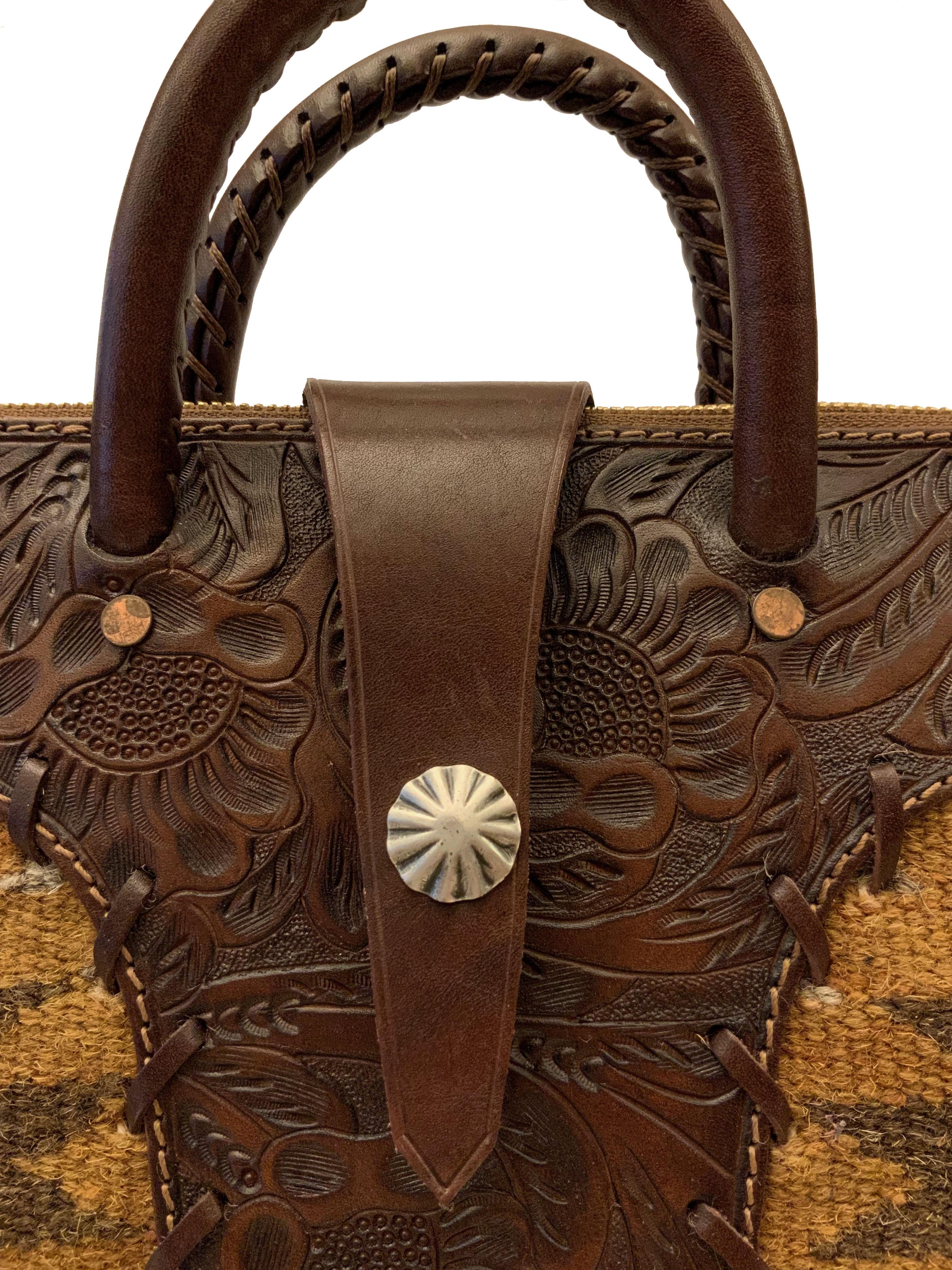 This bag from the house of Ralph Lauren RRL is made from naturally dyed hand-woven textiles with a 30's Southwestern inspired pattern.
The leather panels are hand-tooled.
The double handle allows a hand carry and the adjustable strap goes for the