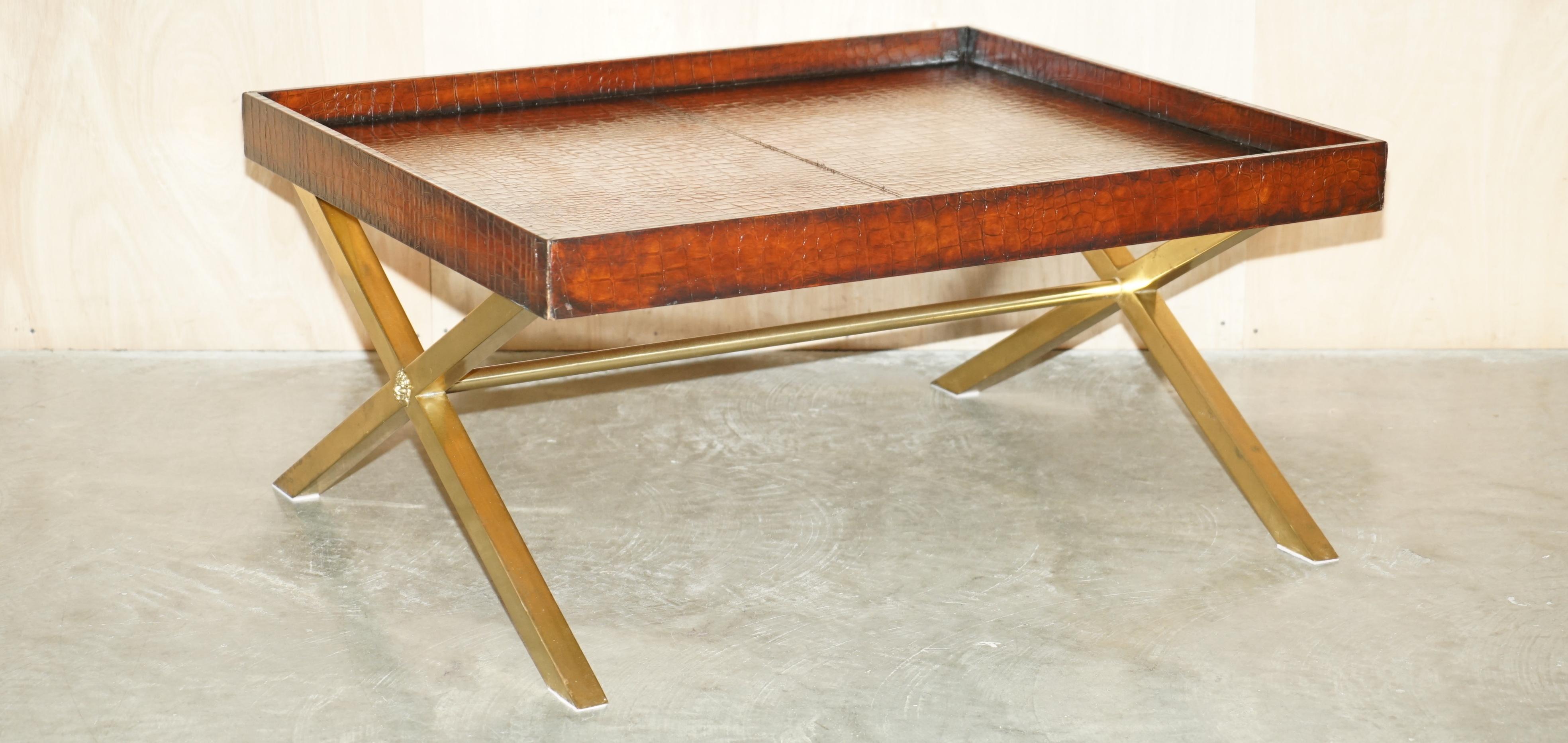 Royal House Antiques is delighted to offer for sale this stunning fully restored Ralph Lauren hand dyed cigar brown Crocodile patina leather X framed coffee or cocktail table with Lion's had central mains

This is the only one of these tables