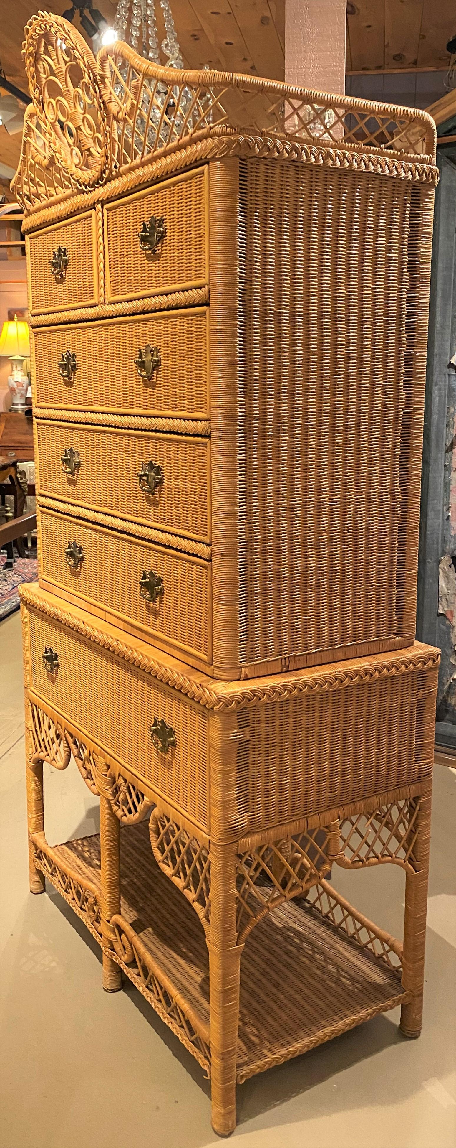 A fine two part wicker highboy by Ralph Lauren with a split pediment rattan crest with central oval decoration surmounting an upper case with a two over three drawer configuration with wicker fronts, over a lower case with single long drawer over a