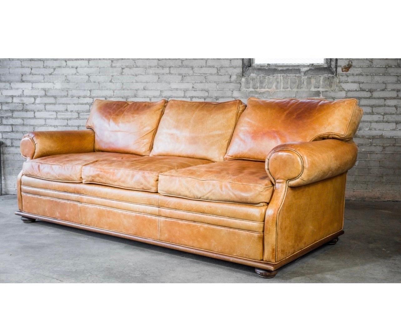 Elegant and rare Ralph Lauren saddle leather sofa with lovely patina. Structurally sound. Features large round rolling armrests, an angular back, and a perfect blend of modern style mixed with English traditional attributes. The butter soft leather