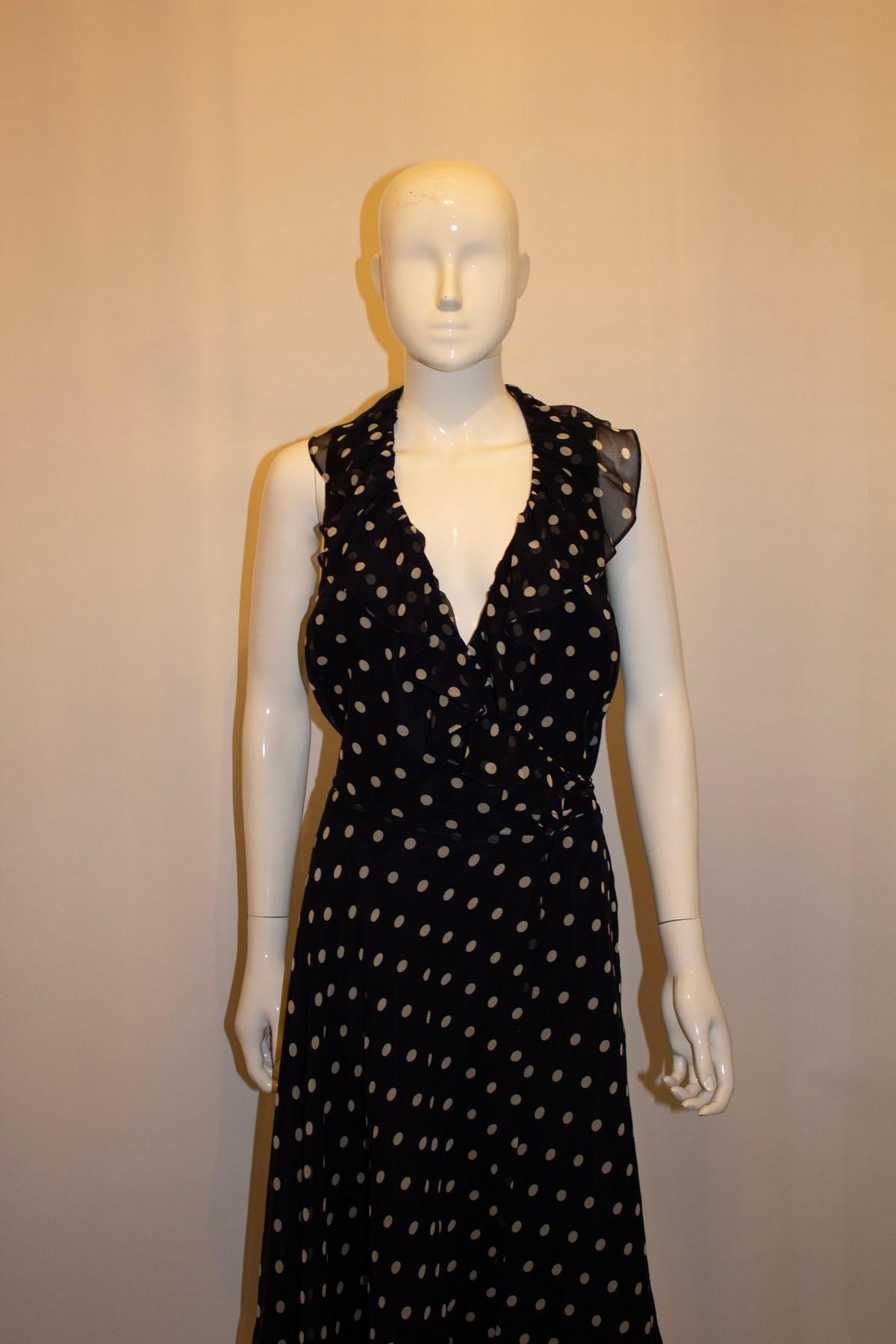 Ein verspieltes und kokettes Seidenkleid von Ralph Lauren. Das blau gefärbte Kleid mit weißen Tupfen hat eine Wickelvorderseite mit Rüschenausschnitt und Stoffgürtel. Das Kleid ist gefüttert. 
Maße: Büste bis zu 42'', Länge 40''