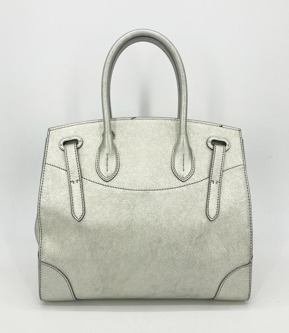 Ralph Lauren Silver Leather Rickey Bag in good condition. Silver leather exterior trimmed with silver hardware. Front sliding latch and double buckle closure opens to a black leather interior with one slit side pocket. overall good condition. a few