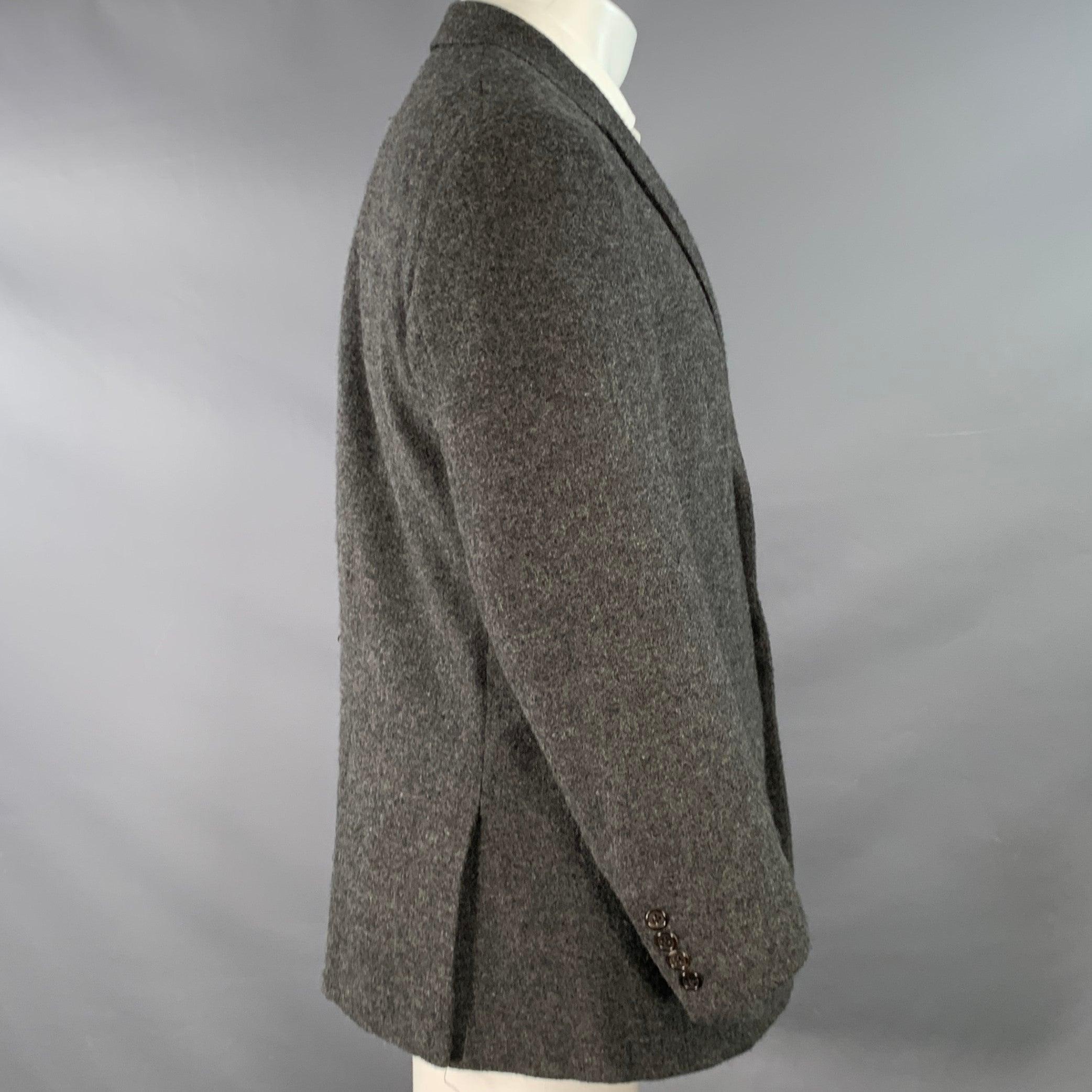 RALPH LAUREN PURPLE LABEL sport coat
in a heather grey and black cashmere alpaca blend fabric featuring a notch lapel, double vented back, and three button closure. Note: the sleeves on this garment have been professionally altered and are slightly