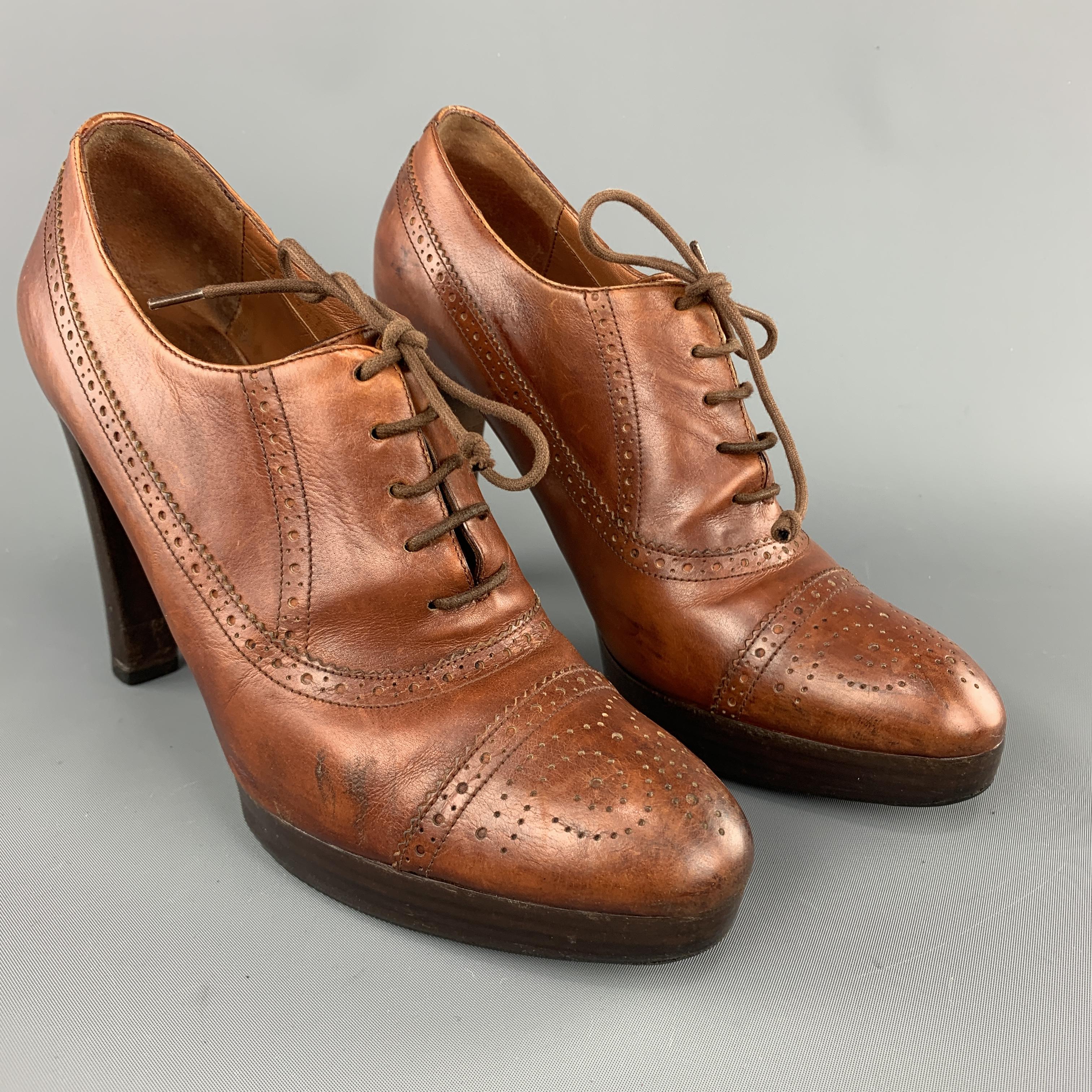 RALPH LAUREN COLLECTION oxford pumps come in tan leather with stacked heel and platform. Wear throughout. As-is. Made in Italy.

Good Pre-Owned Condition.
Marked: US 8 B

Heel: 4.45 in.
Platform: 0.75 in.