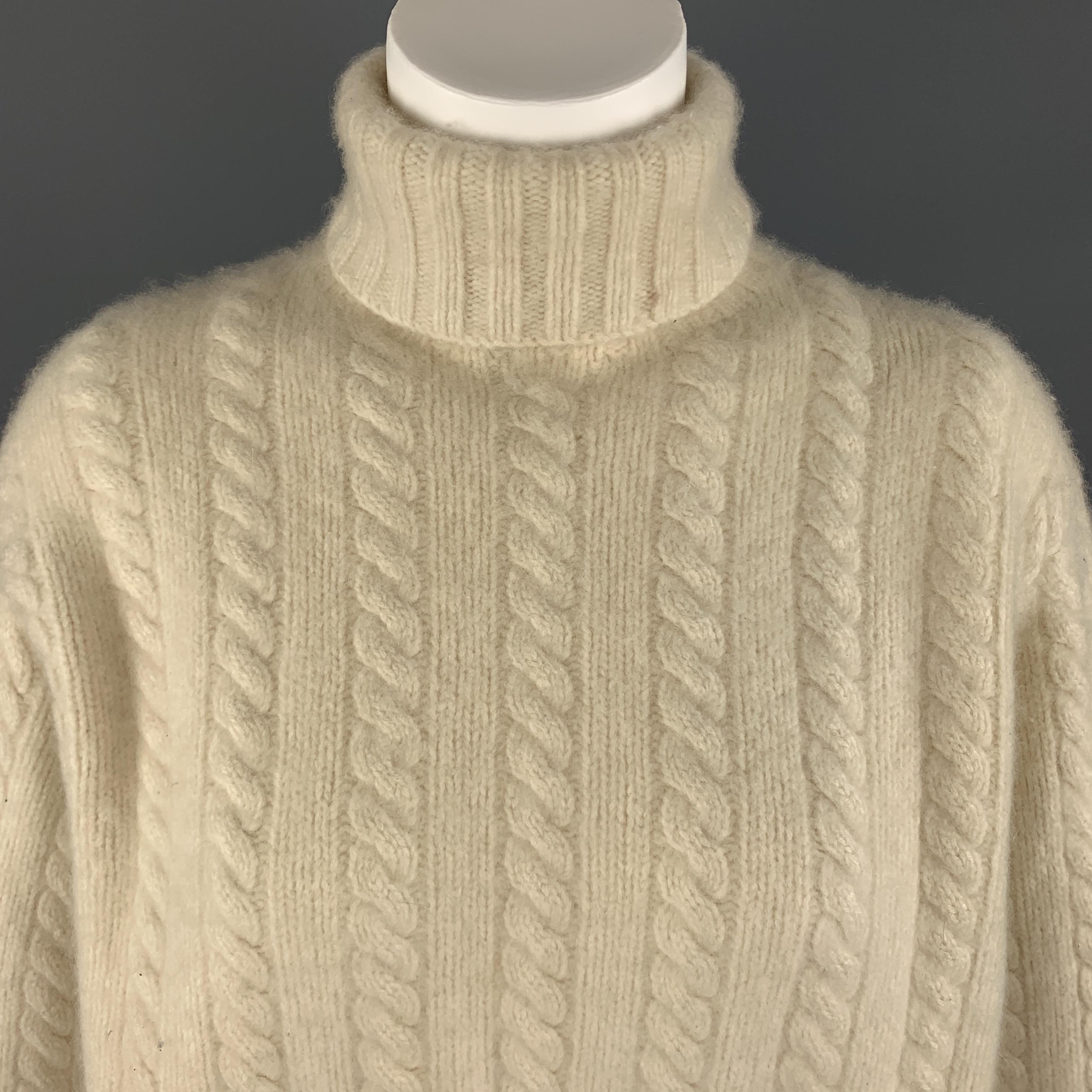 Oversized RALPH LAUREN sweater comes in cream cashmere cableknit with a rolled turtleneck. 

Excellent Pre-Owned Condition.
Marked: L

Original Retail Price: $1,295.00

Measurements:

Shoulder: 17 in.
Bust: 40 in.
Sleeve: 24 in.
Length: 25 in.