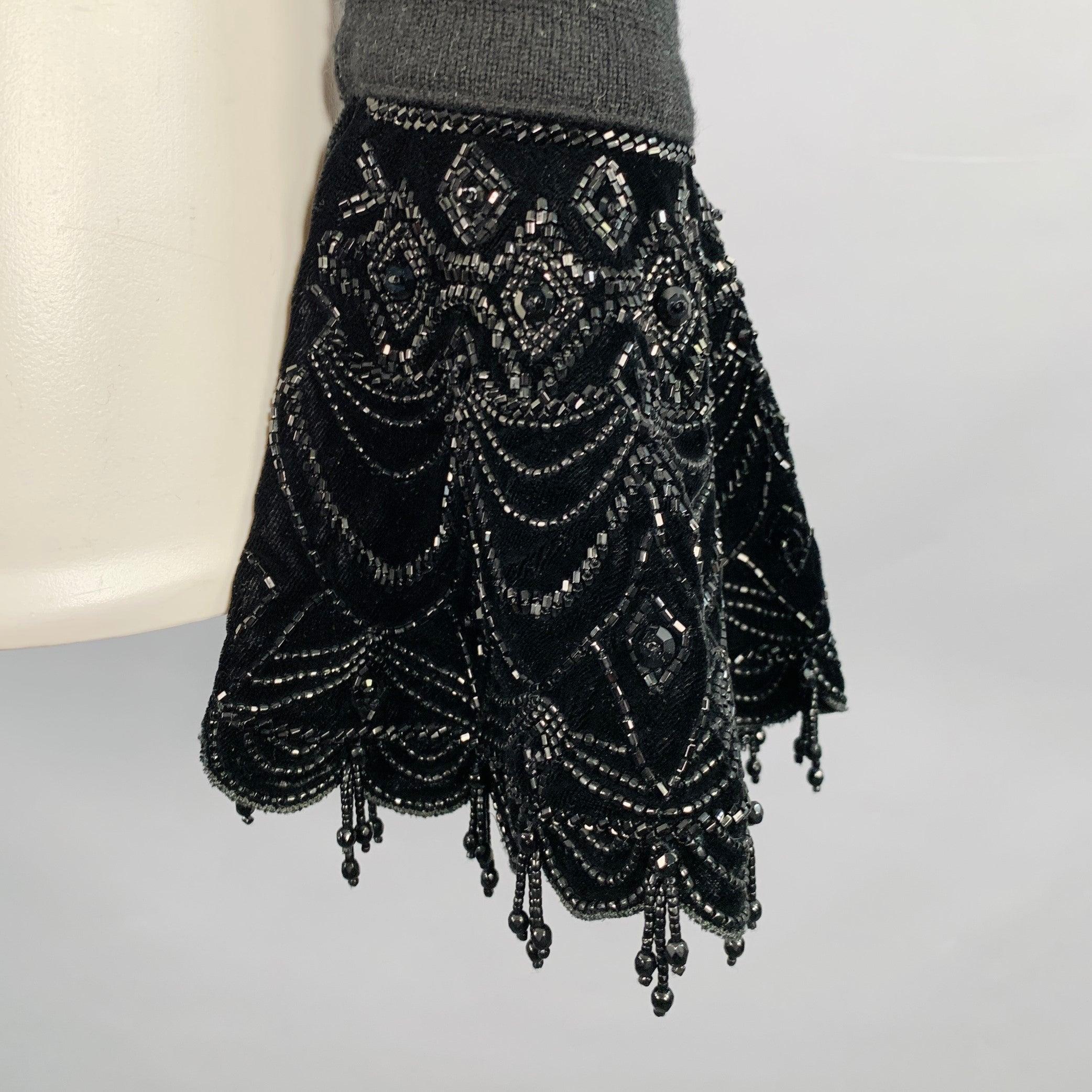 Top de vestido RALPH LAUREN
de punto de cachemira negro con puños acampanados de terciopelo negro con un bonito diseño de cuentas y cuello en V. Muy buen estado de segunda mano. Pequeño pilling, etiqueta de marca quitada. 

Marcado:   Tamaño no