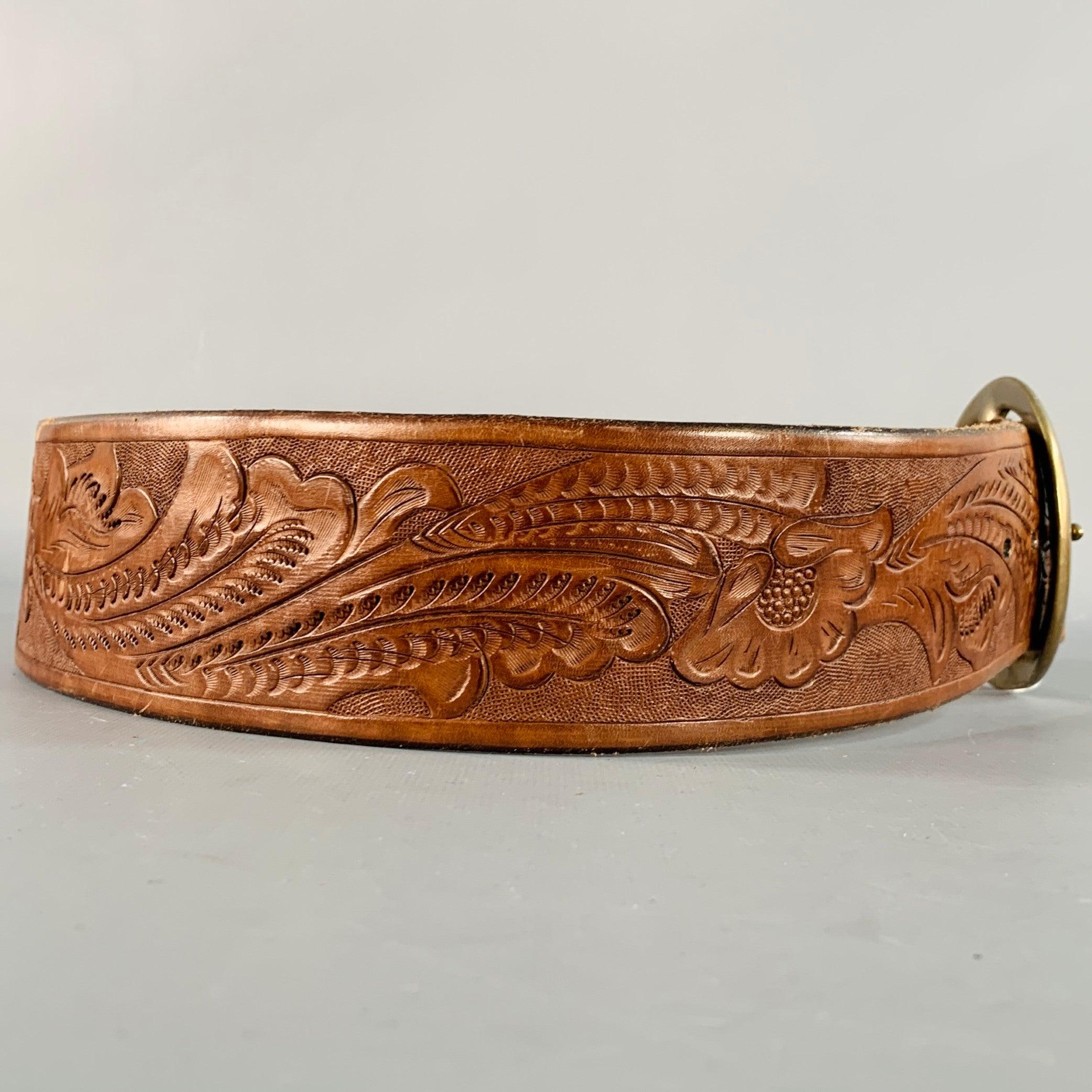 RALPH LAUREN belt in a brown embossed leather featuring a floral design , wide style, and round brass metal buckle. Excellent Pre-Owned Condition. 

Marked:   411130091236Length: 38.5 inches Width: 2.5 inches Fits: 31 inches  - 35 inches Buckle: 3.5