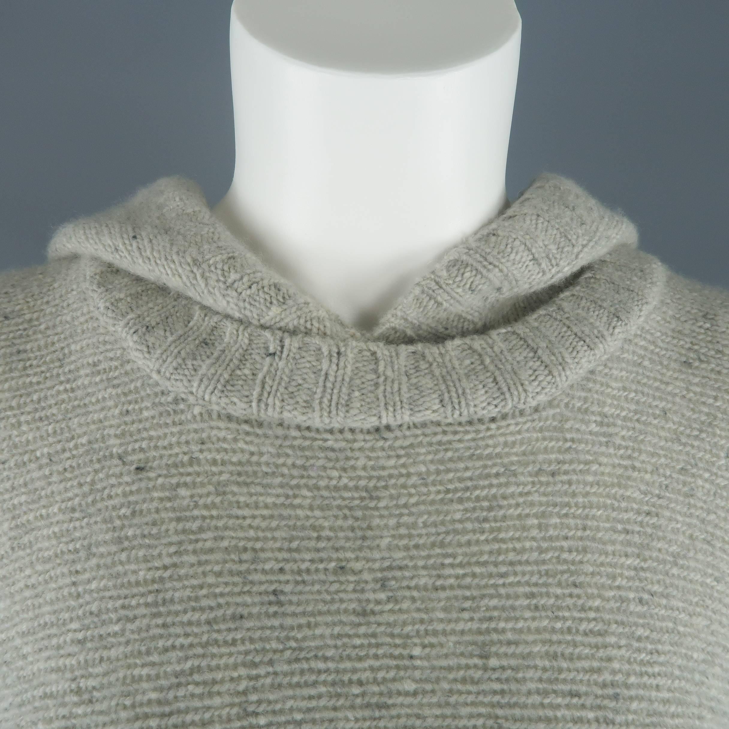Ralph Lauren Black Label poncho comes in light speckled gray cashmere knit and features a round neck with hood, frontal hoodie pocket, and half closed sides.
 
Excellent Pre-Owned Condition.
Marked: M/L
 
Measurements:
 
Width: 44 in.
Length: 31 in.