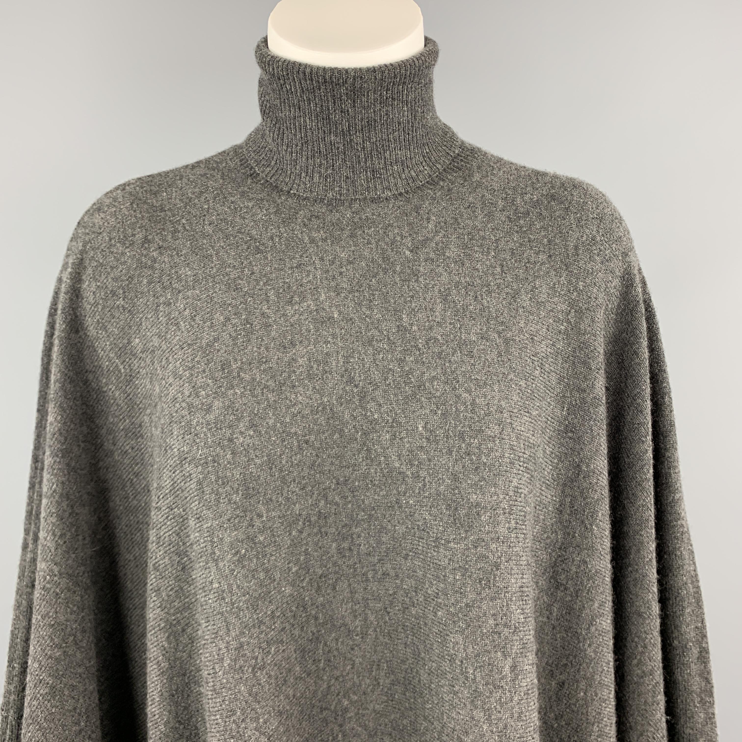 RALPH LAUREN Blue Label cape comes in charcoal gray cashmere with a turtleneck and draped body.

Excellent Pre-Owned Condition.
Marked: XSS

Width: 55 in.
Length: 30-38 in.