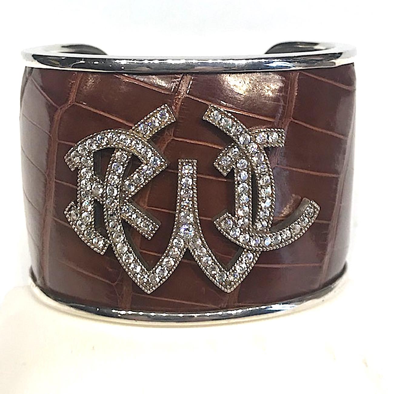 Heavy Ralph Lauren sterling silver cuff with stamped cognac color leather in an alligator pattern. The cuff is 2 inches wide and 7.25 long with 1.25 inch opening in the back. The front of the cuff is .25 of an inch thick and tapers to a little over