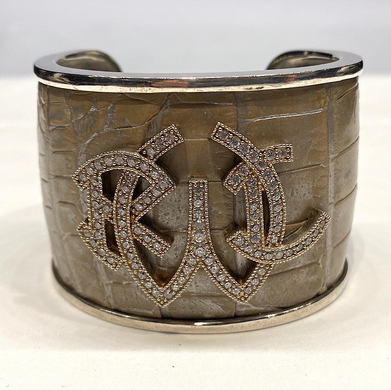 Heavy Ralph Lauren sterling silver cuff with stamped color leather in an alligator pattern. The leather is a combination of metallic matt silver and beige. The cuff is 2 inches wide and 7.25 long with 1.25 inch opening in the back. The front of the