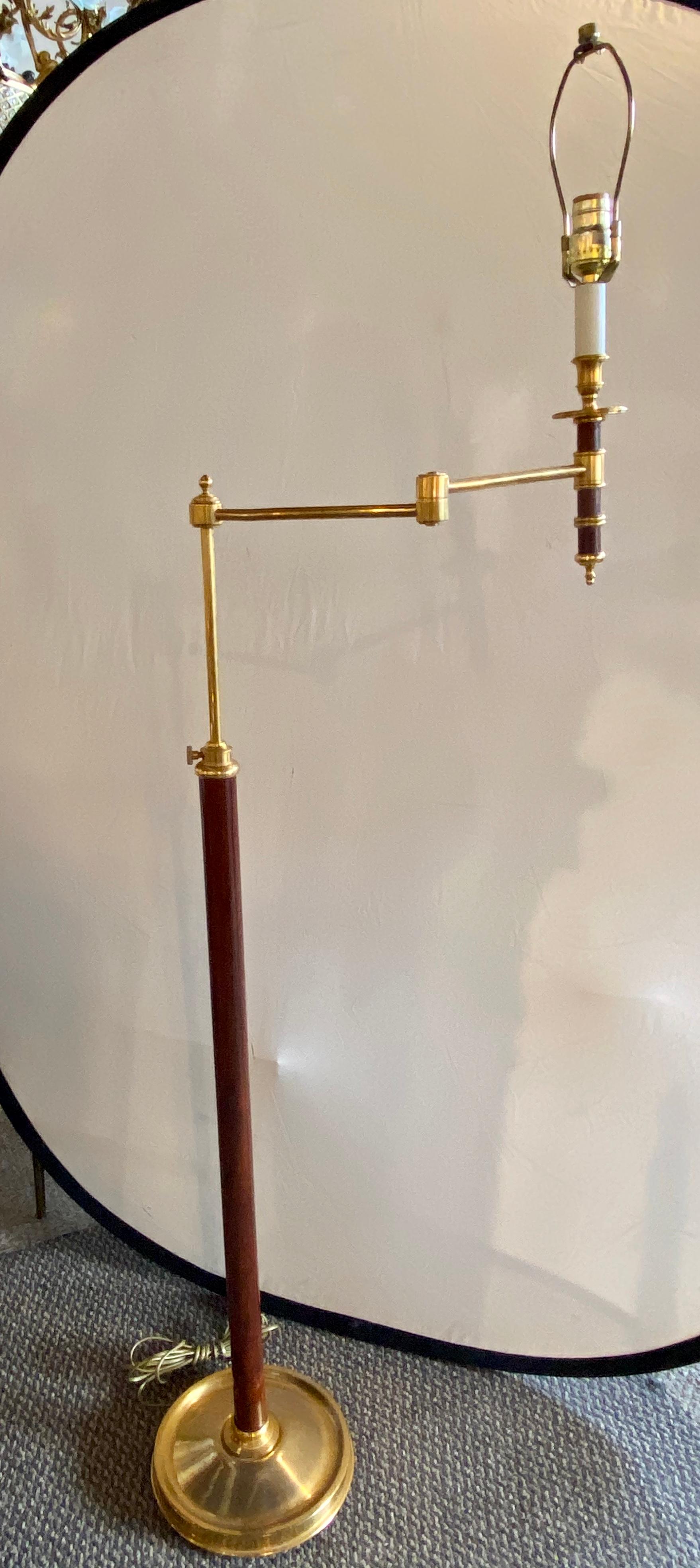 Decorator floor or standing tall lamp. Leather pole with brass custom shade. This finely crafted standing floor lamp is not signed by certainly seems to be by a known designer. The brass weighted circular base supporting a long hand stitched leather