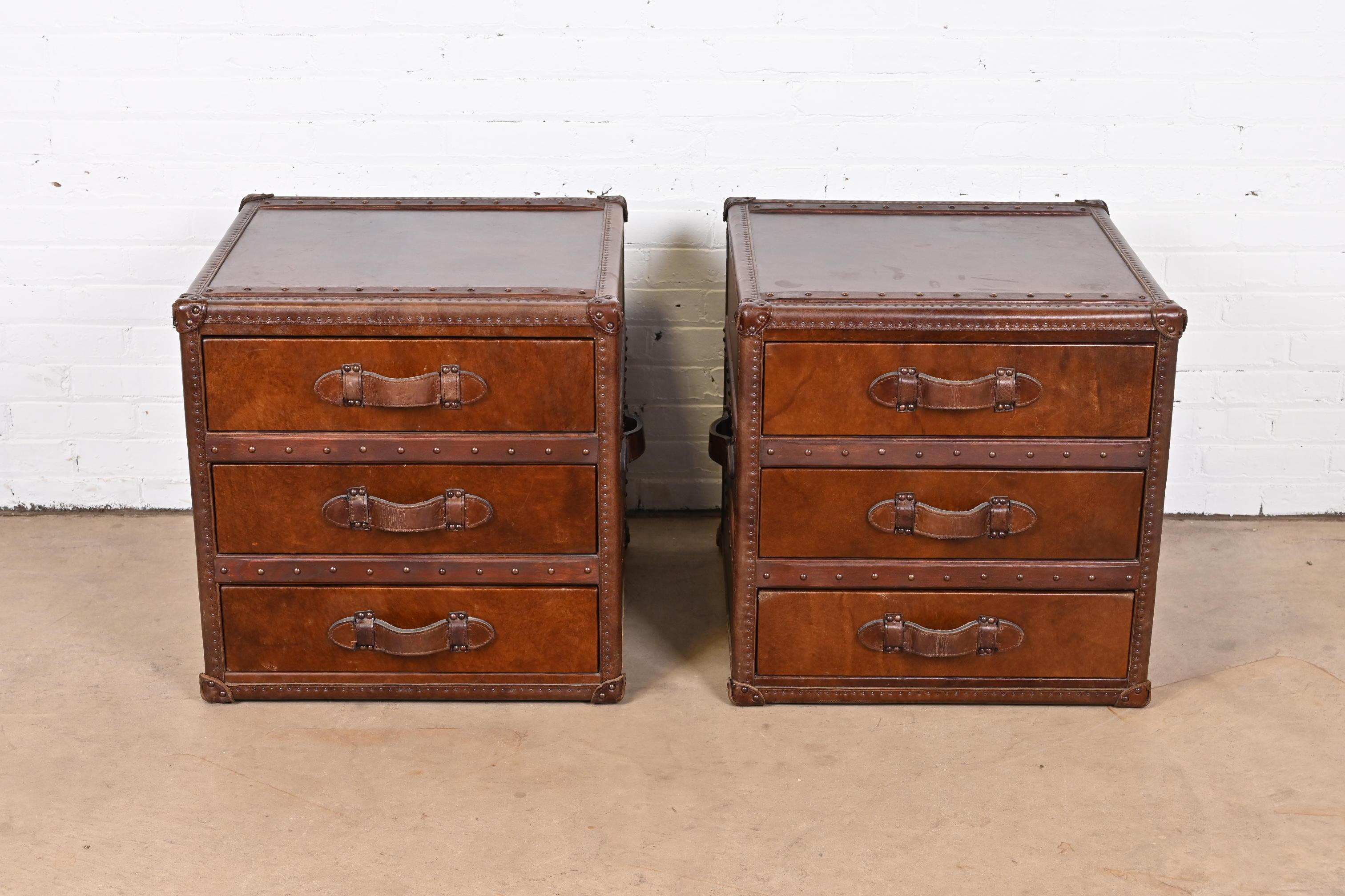 A gorgeous pair of leather wrapped trunk form nightstands or end tables

In the manner of Ralph Lauren

Circa Late 20th Century

Measures: 23.5