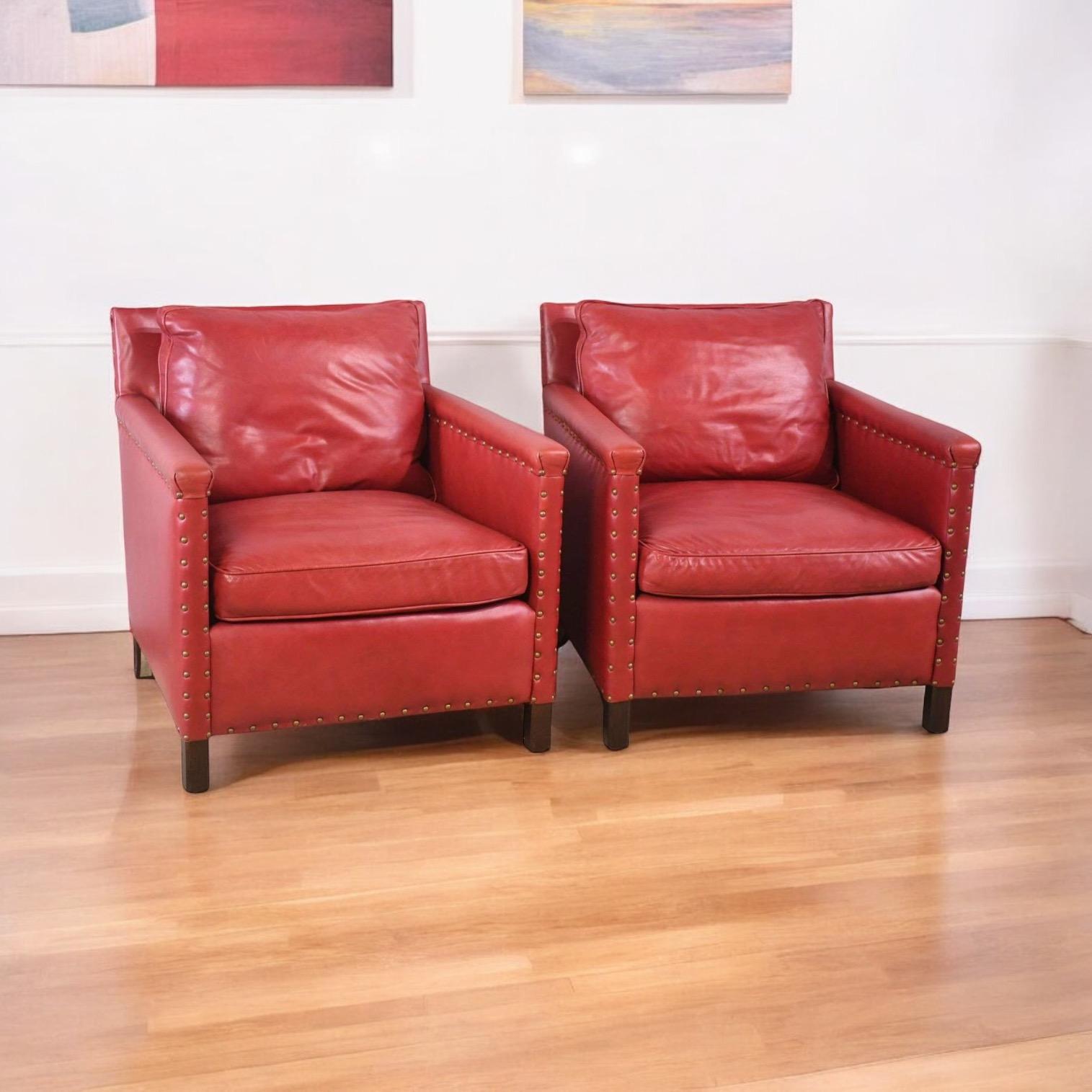 These club chairs have timeless appeal! This is a pair of red leather club chairs with brass trim by Lee Industries. The chairs are in very good condition. The feet are mahogany. From traditional to modern, they would make a strong
