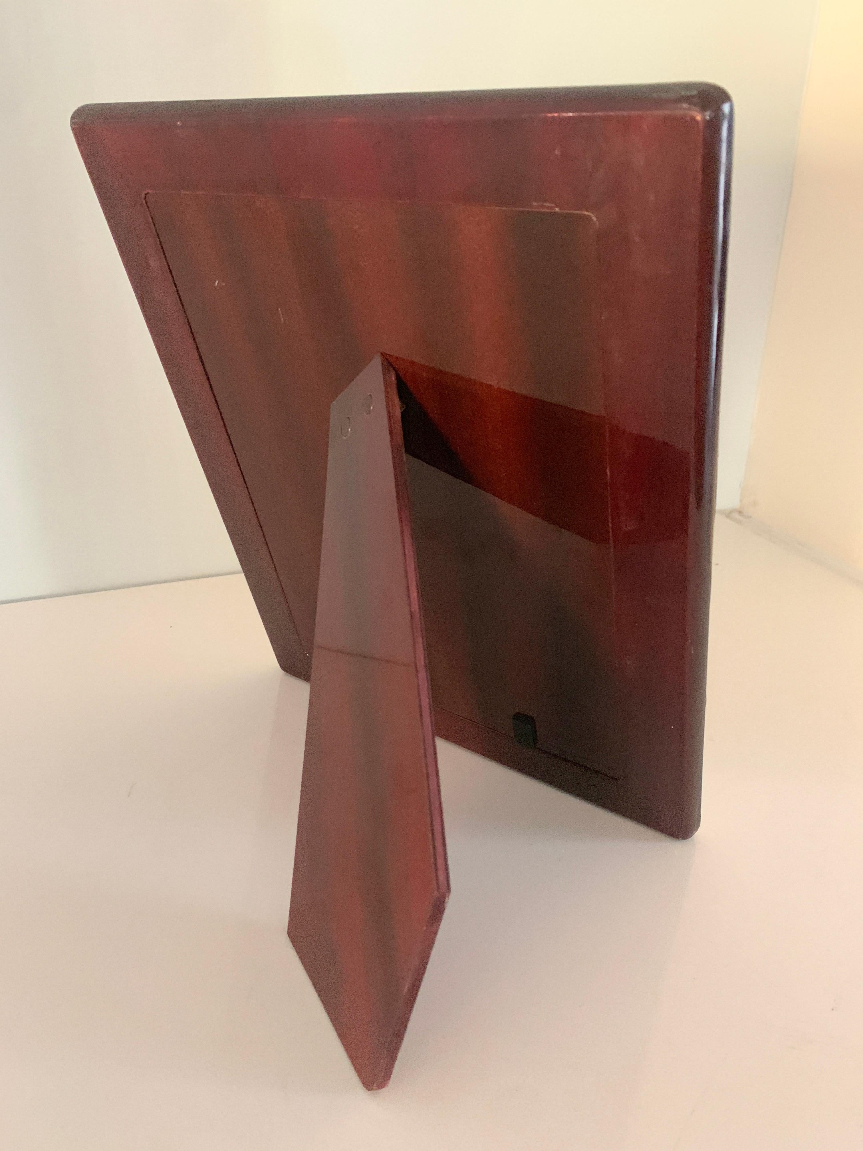 Sterling silver picture frame with Lacquered wood back and support. The sleek architectural design is a compliment to any shelf or desk, the frame has small sculpted 